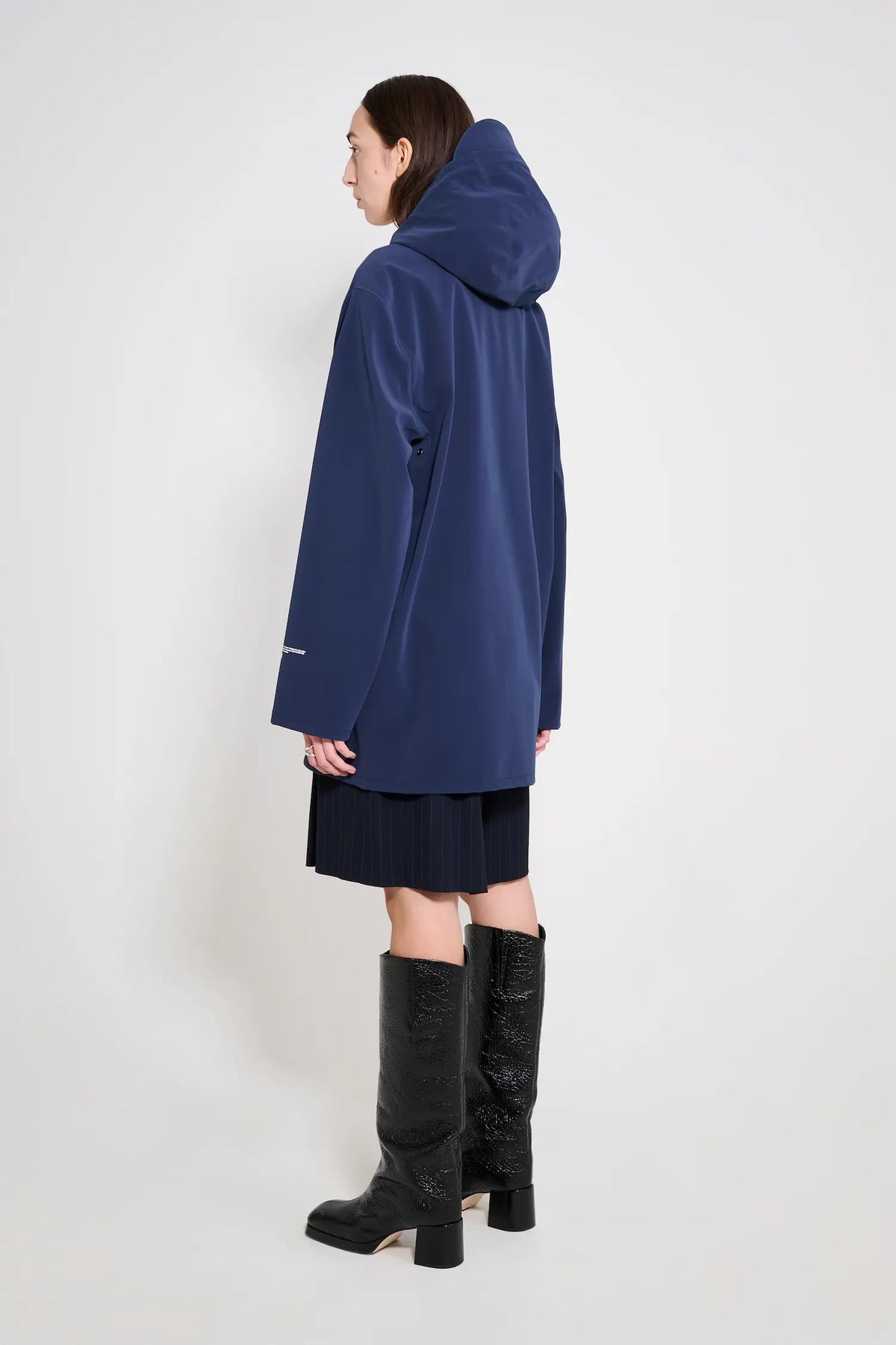 Stockholm Patch Navy Raincoat displayed on a model showcasing its oversized fit and adjustable drawstring hood.