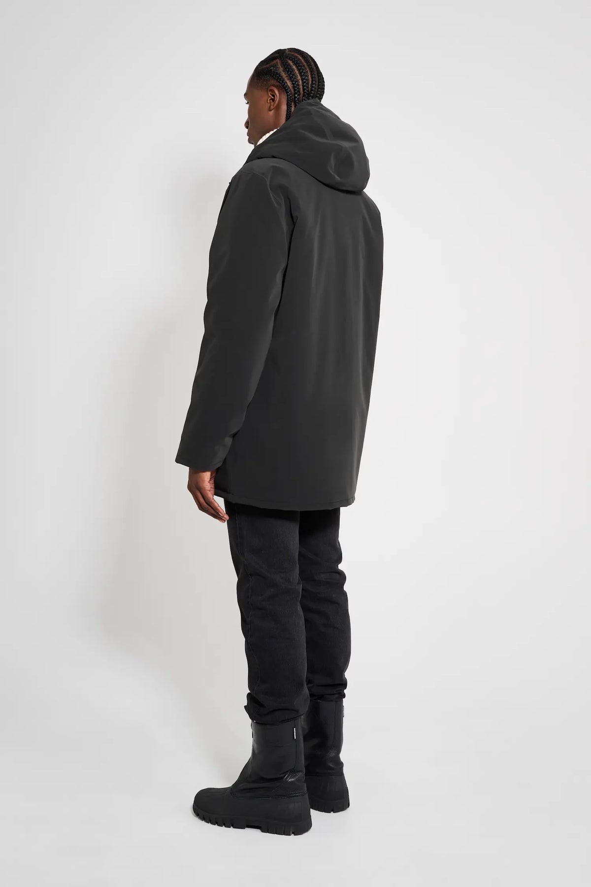 Person wearing Stockholm Matte Black Winter Coat from the back, showcasing its oversized fit and adjustable hood.