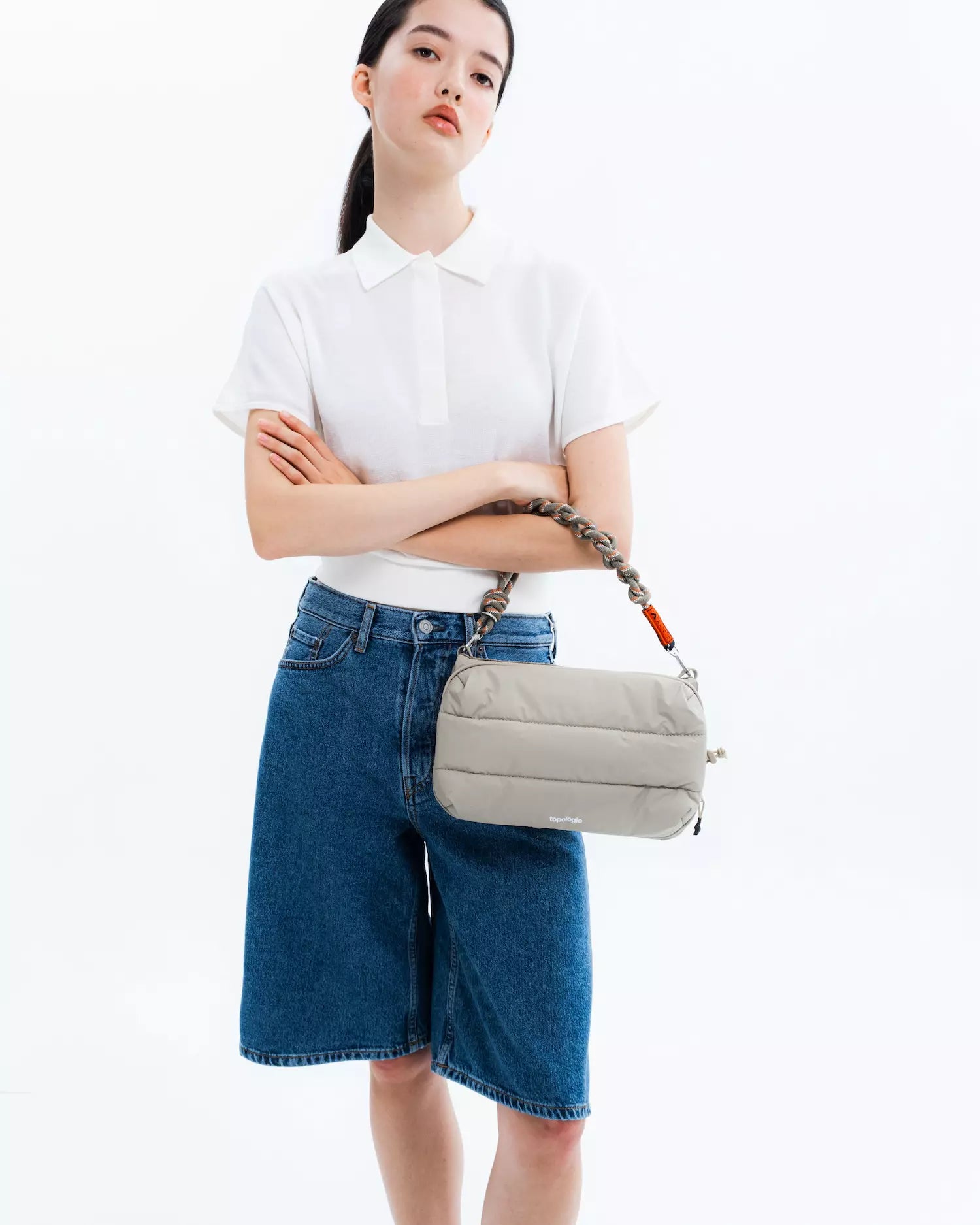 Model wearing Bottle Sacoche Large Moss Silky Peach Bag with stylish outfit, showcasing modern design and functionality.