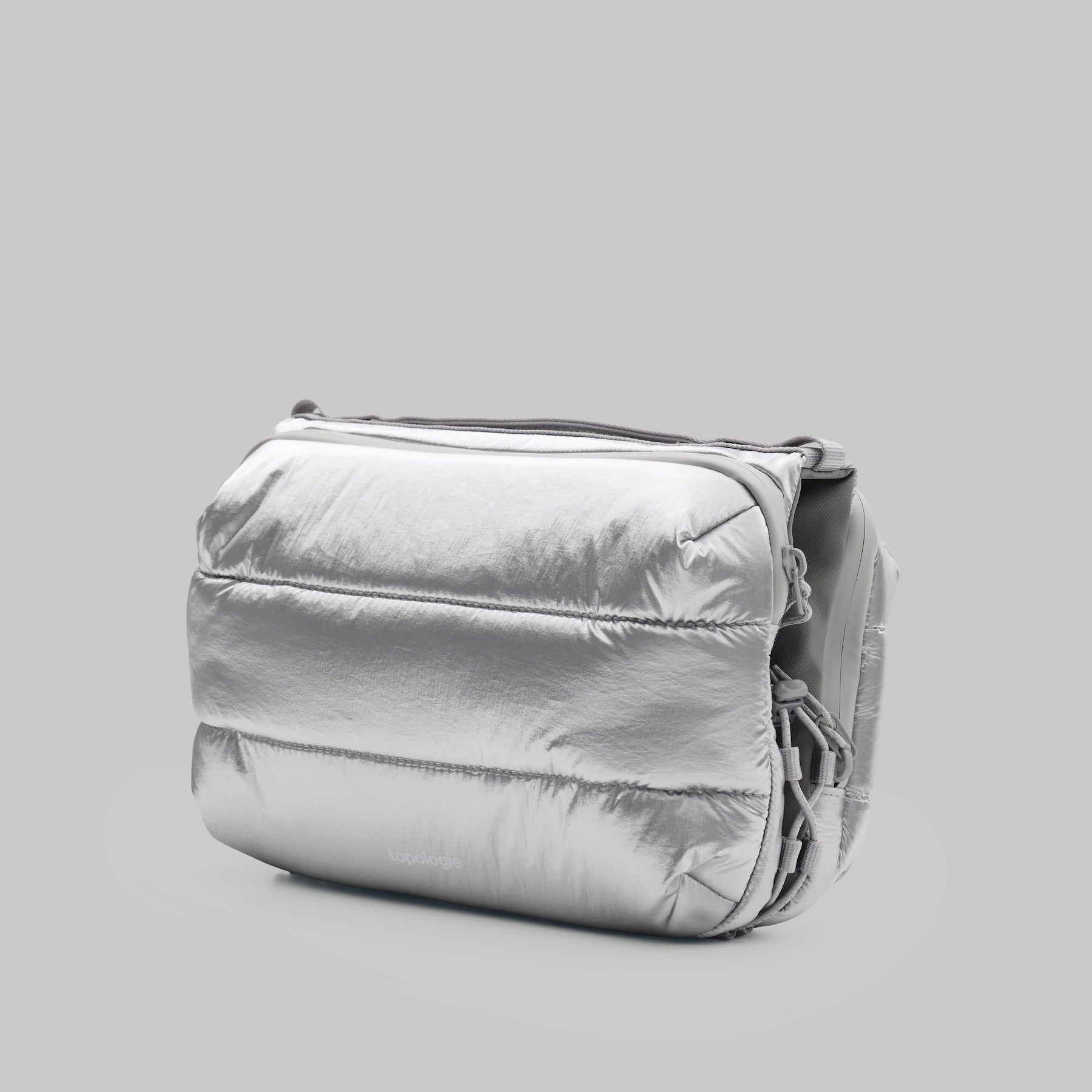 Bottle Sacoche Large Chrome Space Coated Bag in shiny silver color, featuring water repellent fabric and zipped compartments.
