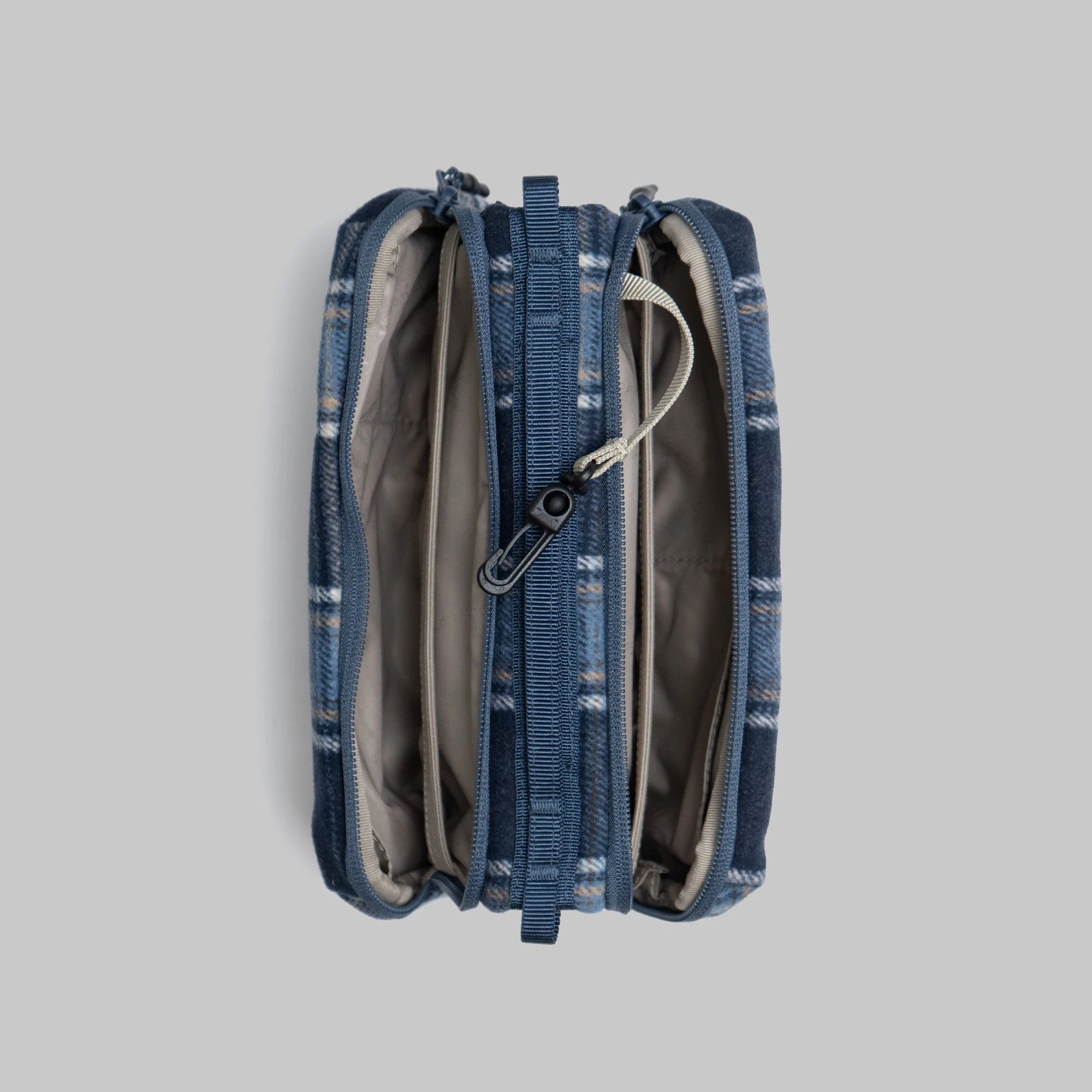 Top view of Bottle Sacoche Medium Blue Check Wool Bag showcasing zipped compartments and internal organizers.