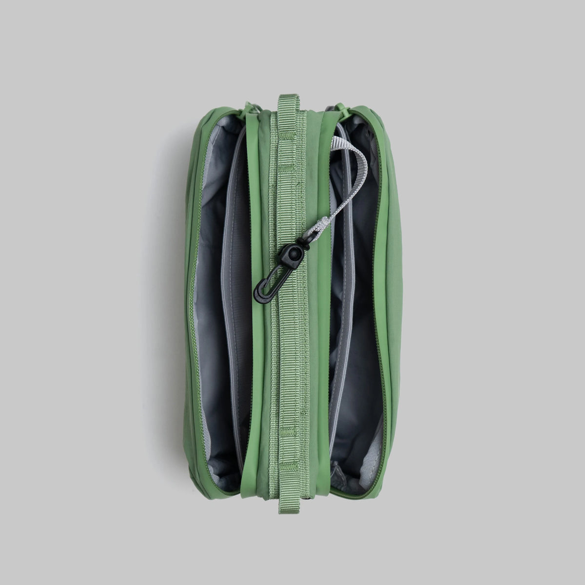 Bottle Sacoche Medium Ivy Green Papery Bag showing internal compartments and zipper details.