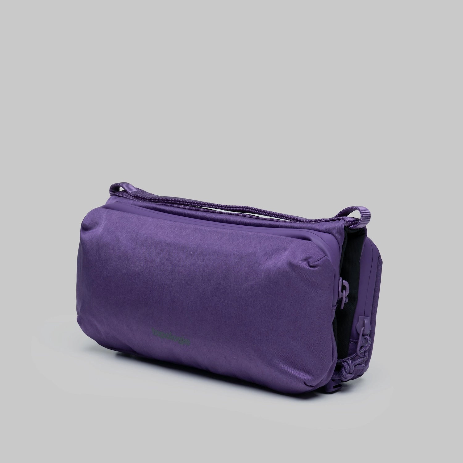 Bottle Sacoche Medium Purple Washed Silk Nylon Bag from a side angle on a gray background.