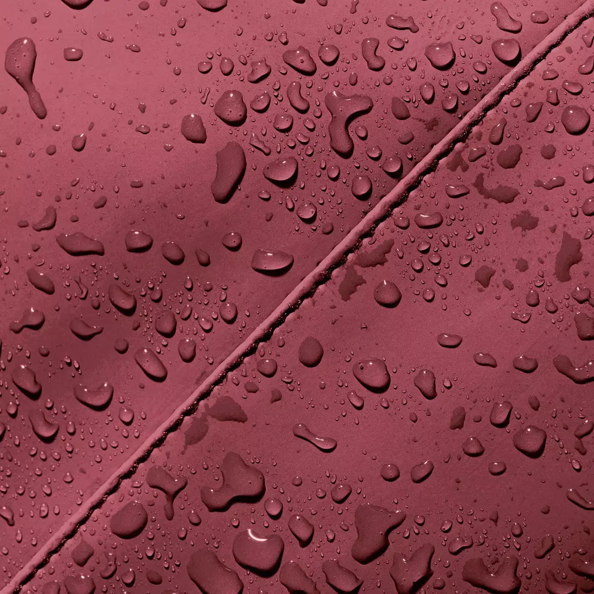Close-up of waterproof fabric with water droplets on Hajo Mini Lotus Infinity Burgundy Backpack.