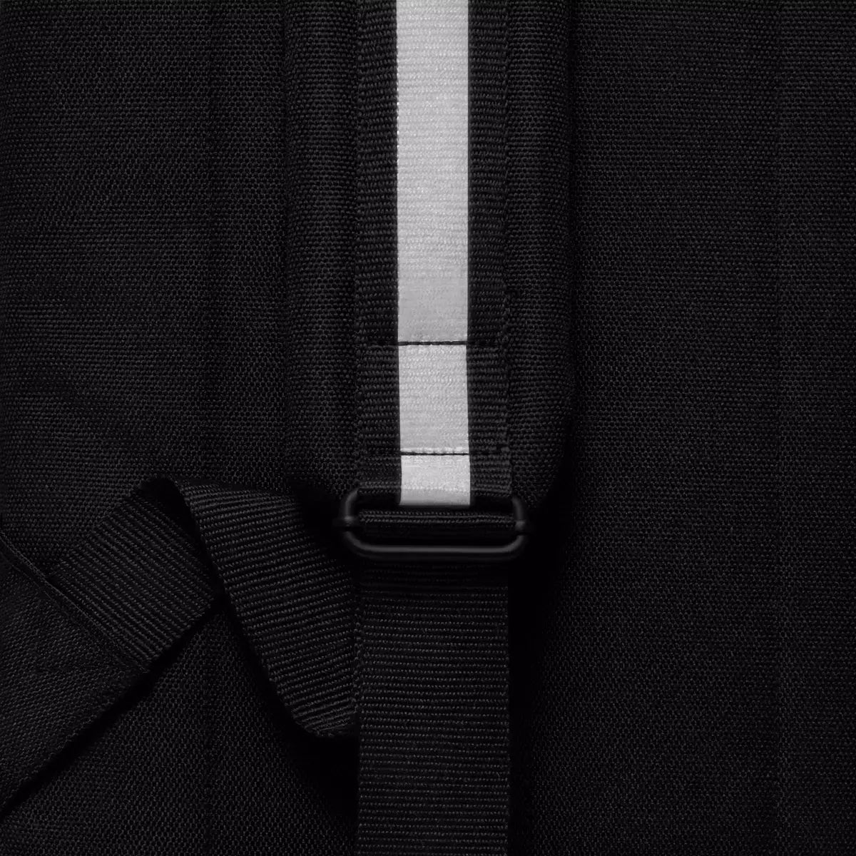 Close-up of the reflective detail on the Jannik Medium Aloe Black Light Grey Backpack's strap.