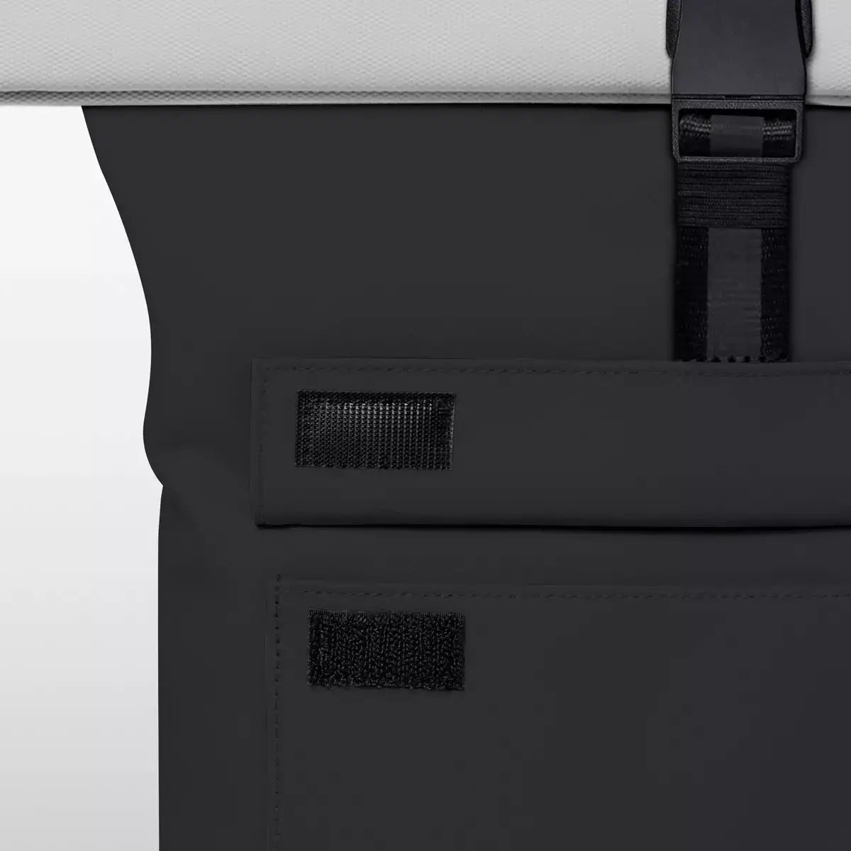 Close-up of the black flap and buckle detail on the Jannik Medium Aloe Black Light Grey Backpack.