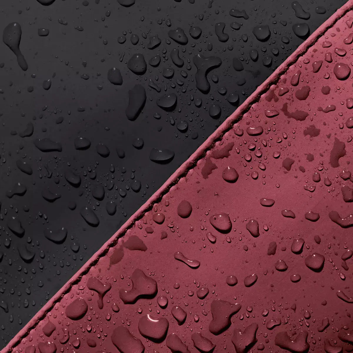 Jannik Mini Lotus Infinity Burgundy Sand Backpack fabric showing water resistance with droplets on black and burgundy material.