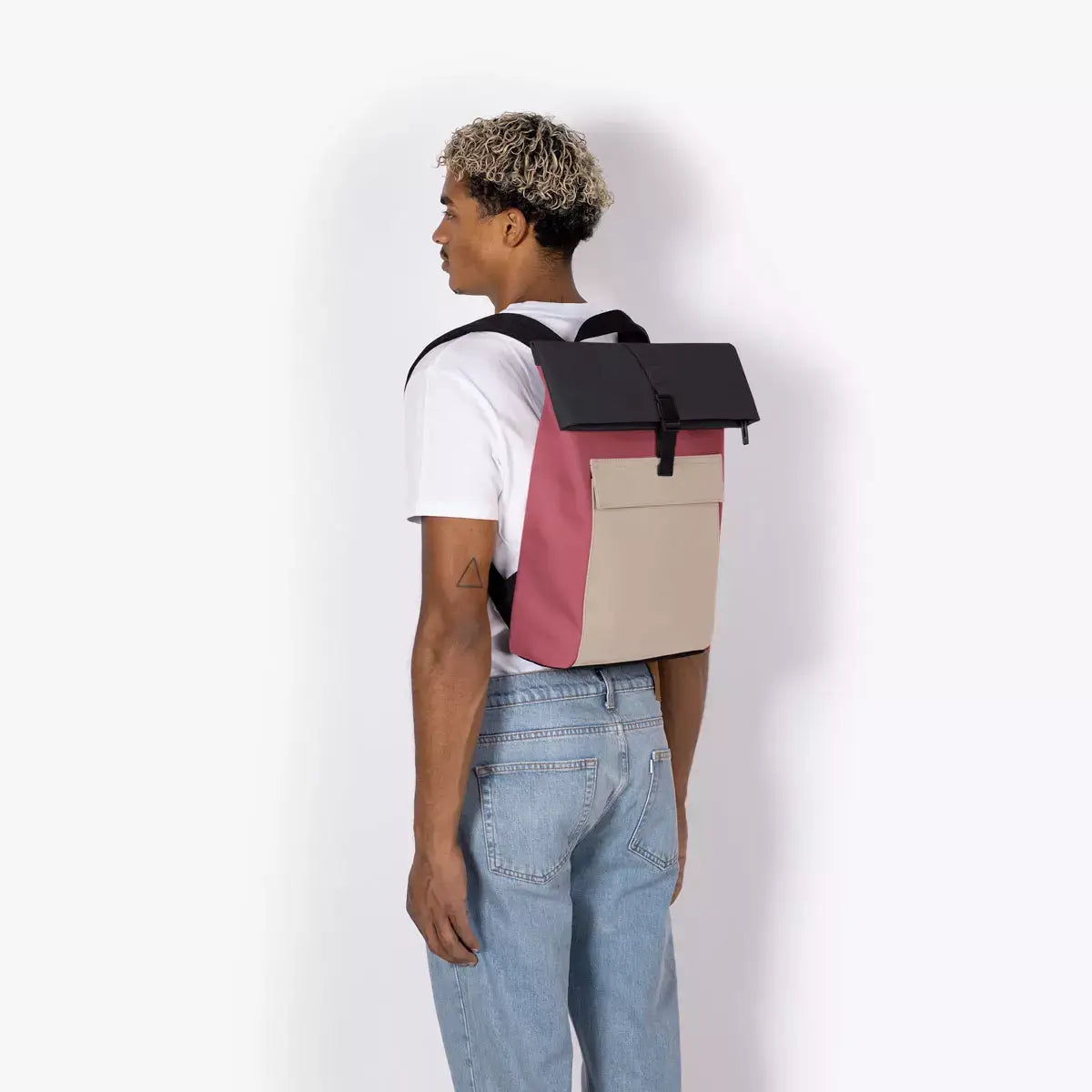 Jannik Mini Lotus Infinity Burgundy Sand Backpack shown on a person from the back, featuring a roll-top design.