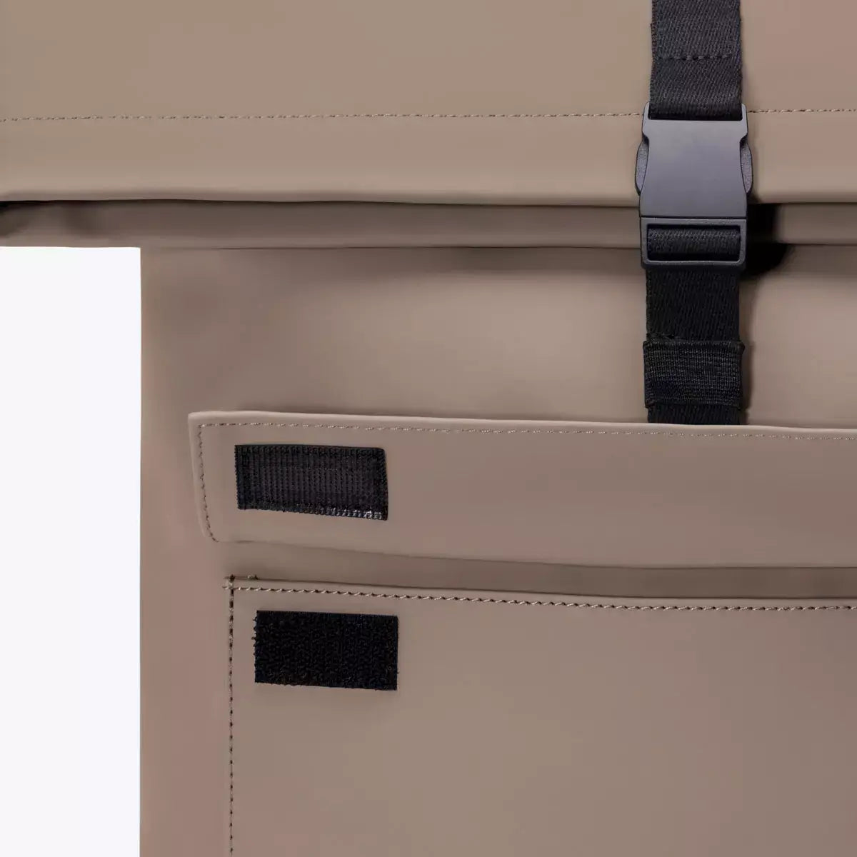 Close-up of the Jannik Mini Lotus Infinity Dark Sand Backpack with roll-top closure and side zipper