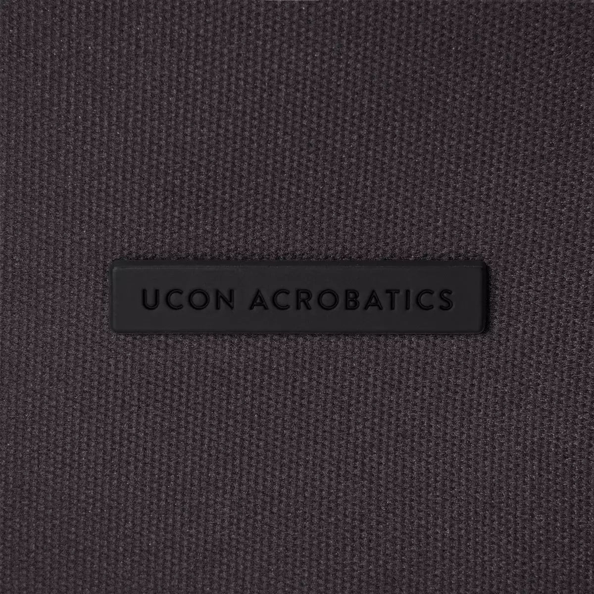 UCON ACROBATICS logo on a dark textile background, showcasing quality and design features.