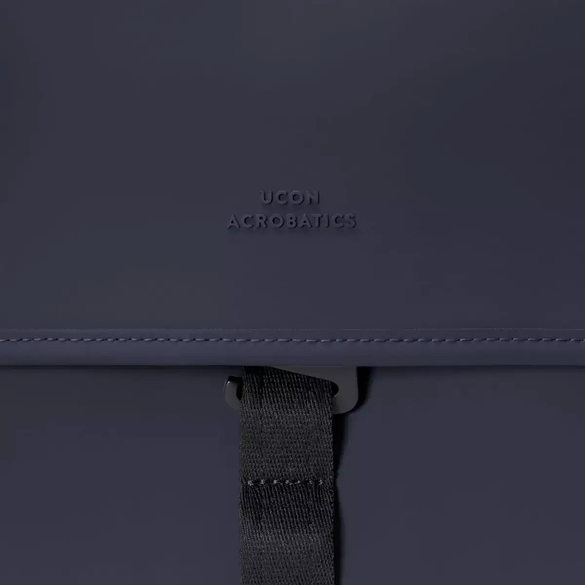 Close-up of Kumo Medium Lotus Infinity Dark Navy Backpack showing logo detail and strap.