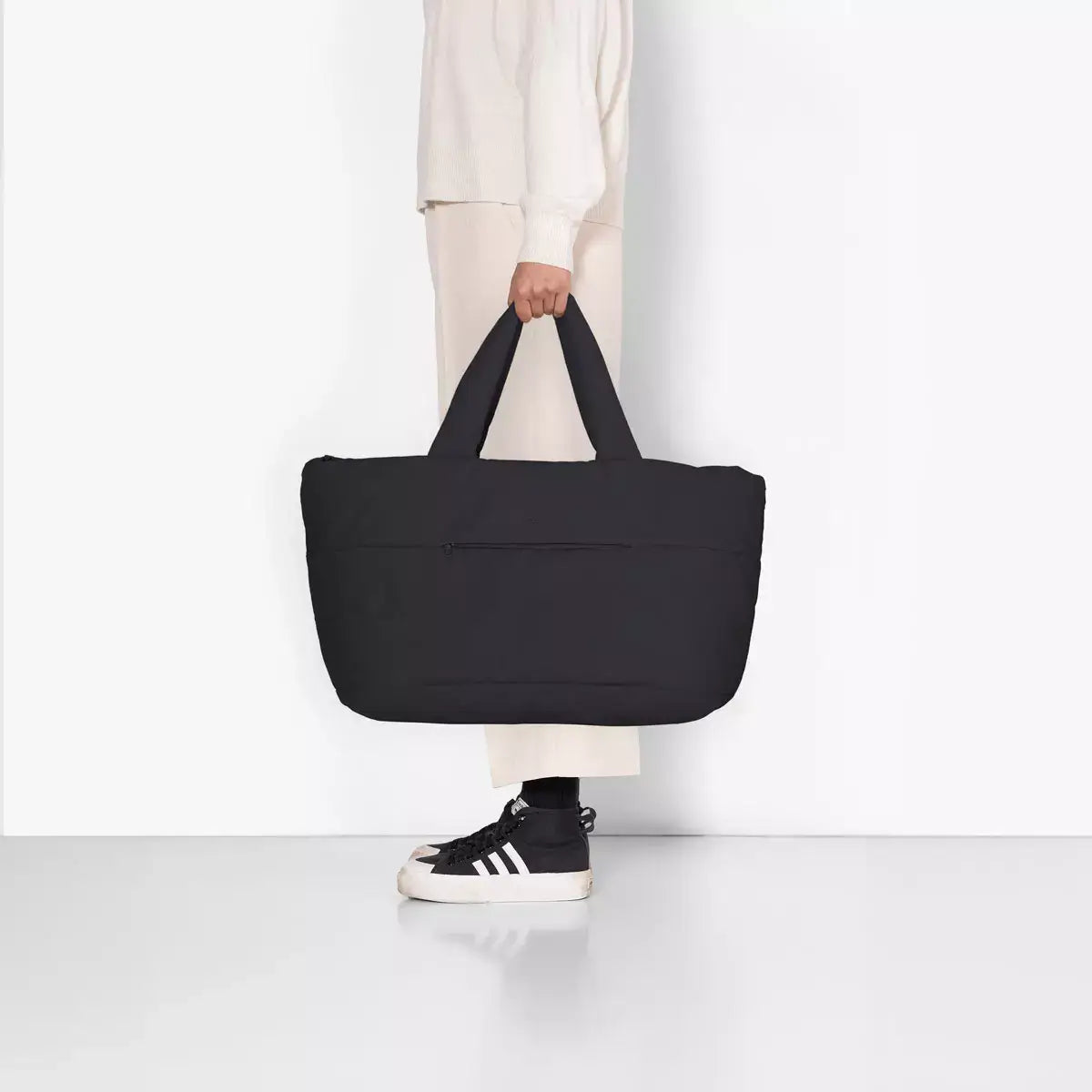Olivia Large Moss Black Shoulder Bag held by a person, showcasing its sleek design and spacious interior.