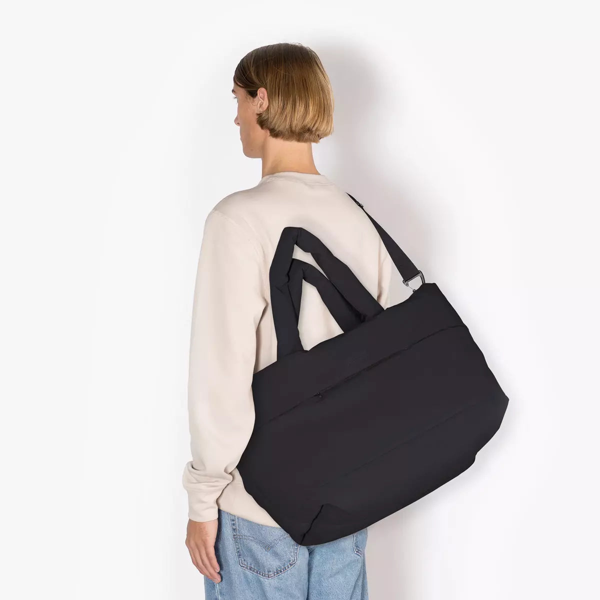 Olivia Large Moss Black Shoulder Bag worn on shoulder, showcasing its sleek design and adjustable straps.