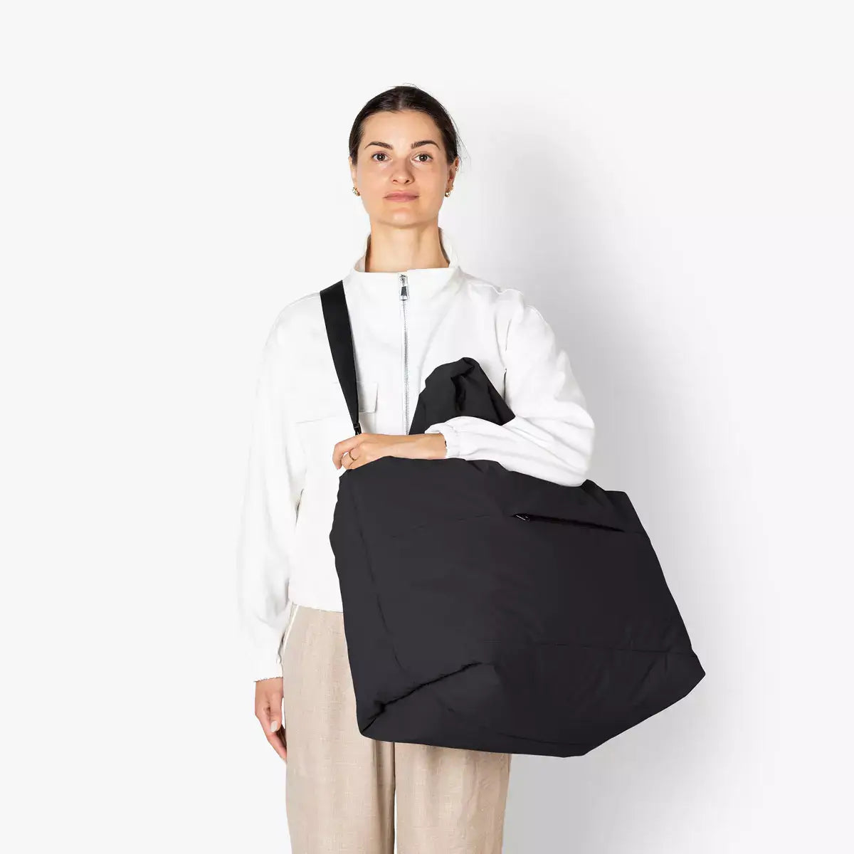 Woman holding Olivia Large Moss Black Shoulder Bag, showcasing its stylish design and practical features.