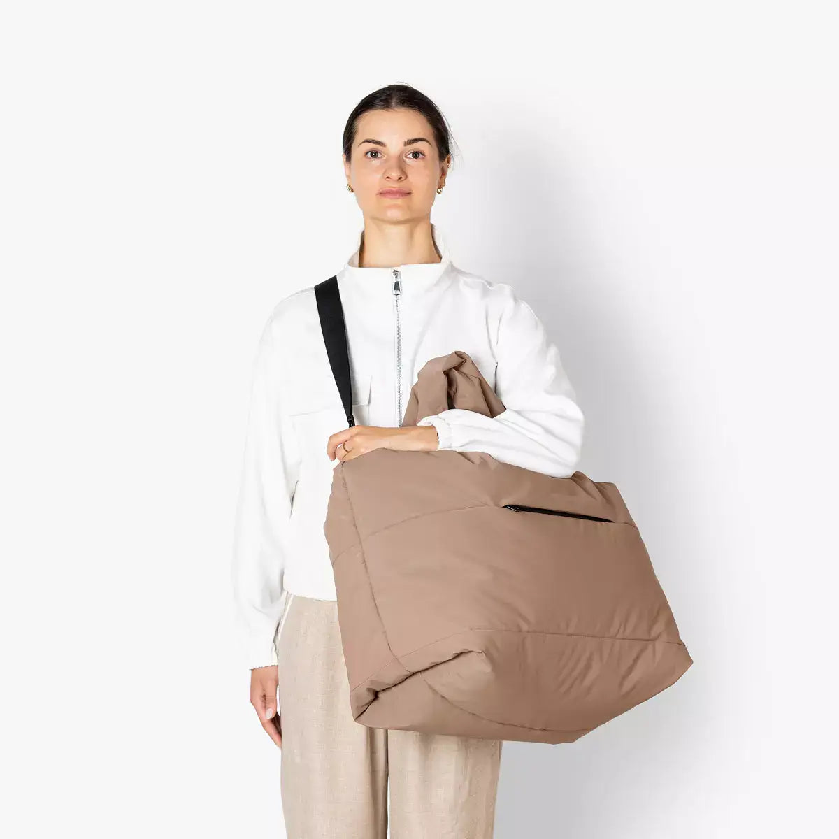 Olivia Large Moss Earth Shoulder Bag being held by a model wearing a white jacket, showcasing its stylish and functional design.