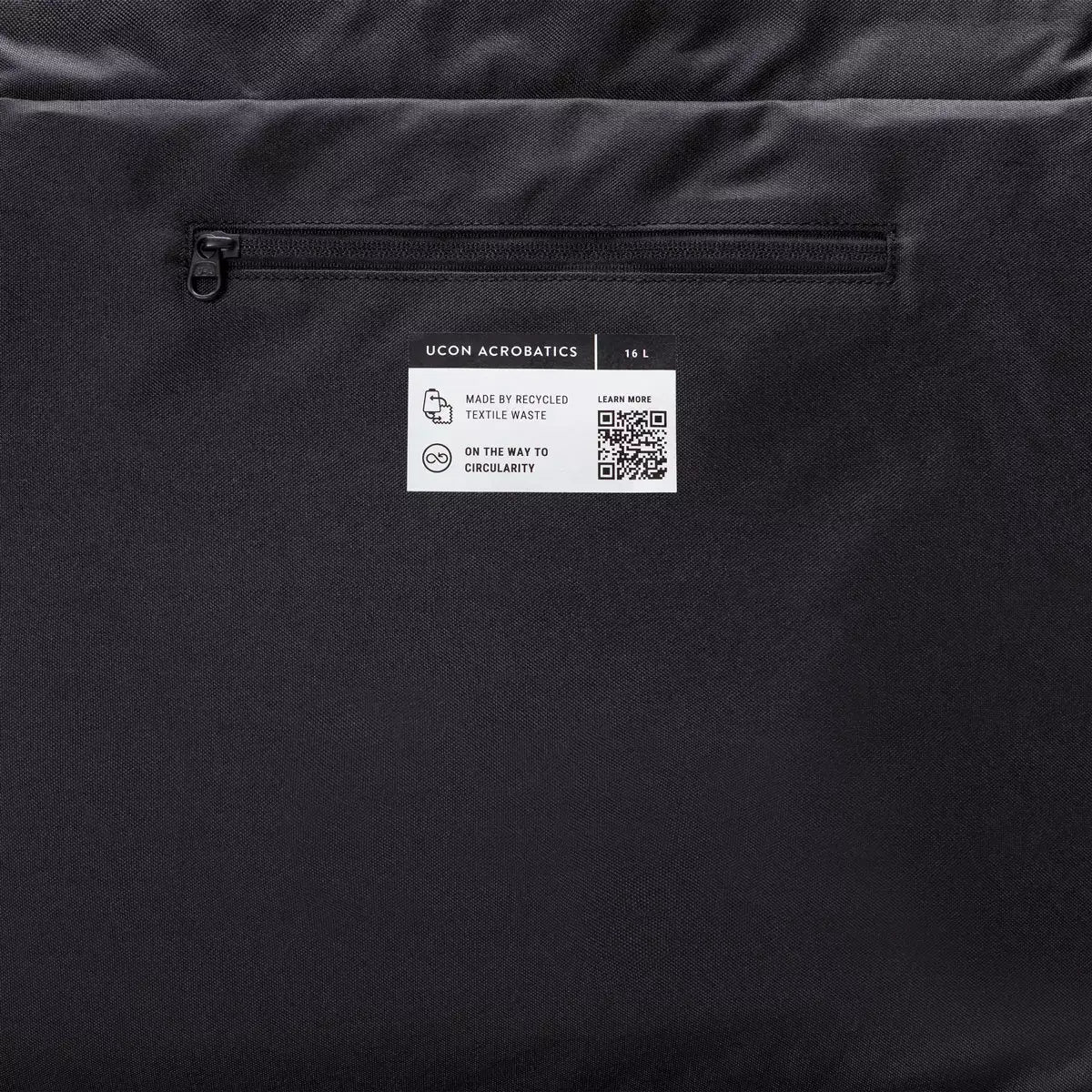 Back view of Olivia Medium Moss Black Shoulder Bag showing zipper pocket and recycled textile label.