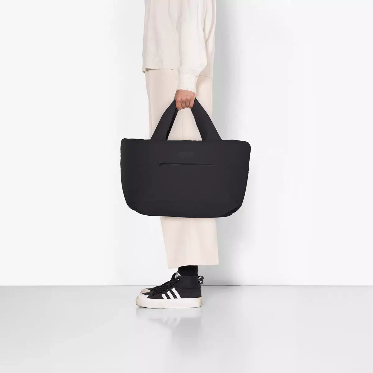 Olivia Medium Moss Black Shoulder Bag held by a person, showcasing its sleek design and functionality.