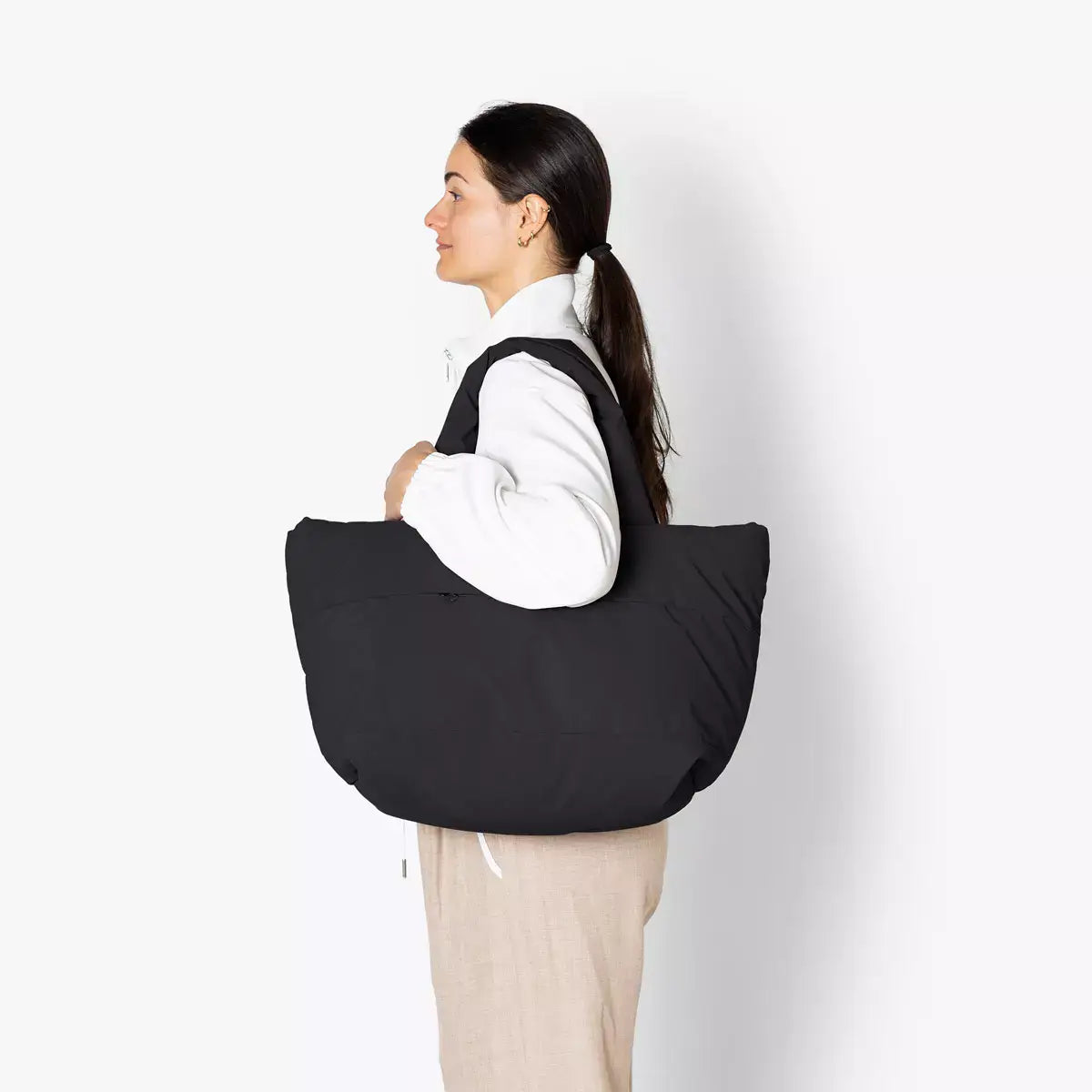 Olivia Medium Moss Black Shoulder Bag showcased by a woman wearing a white jacket, side view, stylish and functional.