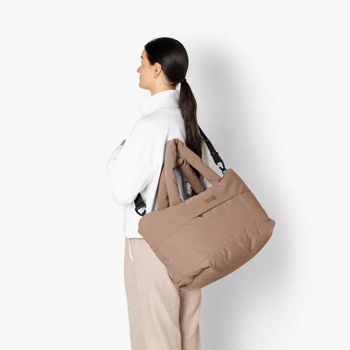 Olivia Medium Moss Earth Shoulder Bag being carried by a woman, showcasing its stylish design and adjustable straps.