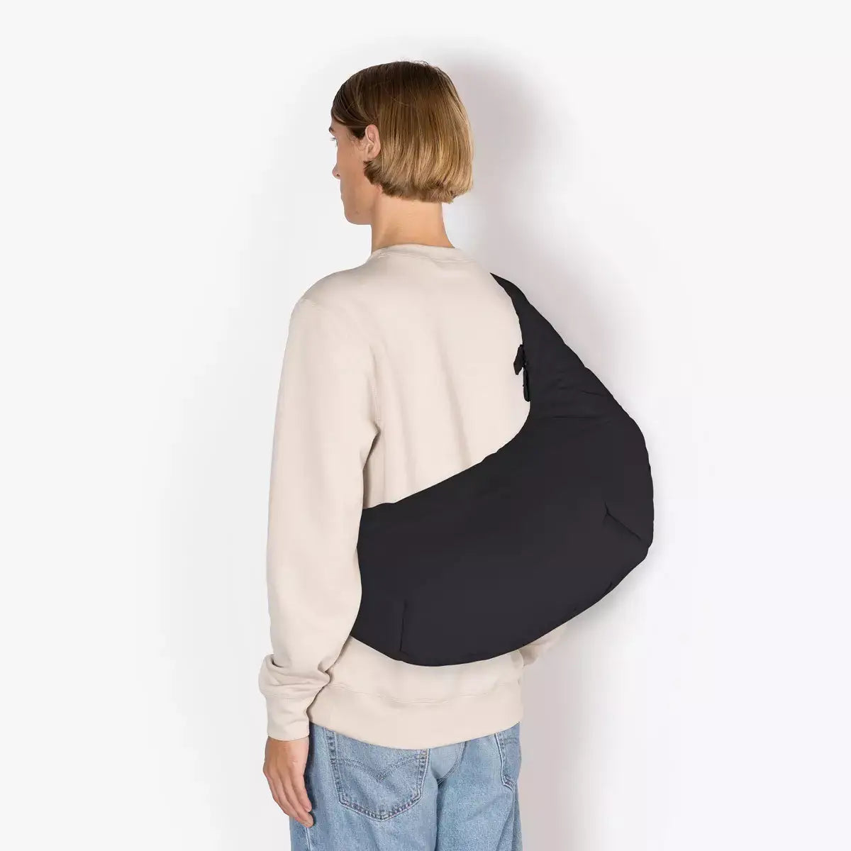 Person wearing Shota Large Moss Black Shoulder Bag from behind, showcasing the adjustable strap and sleek design.