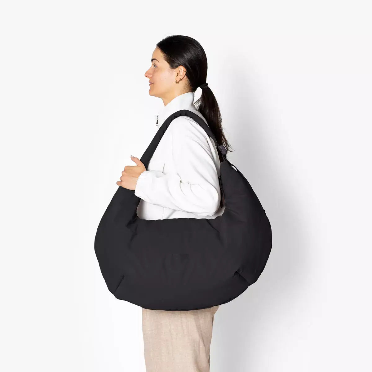 Shota Large Moss Black Shoulder Bag worn by model, featuring a modern design and spacious puffer style.