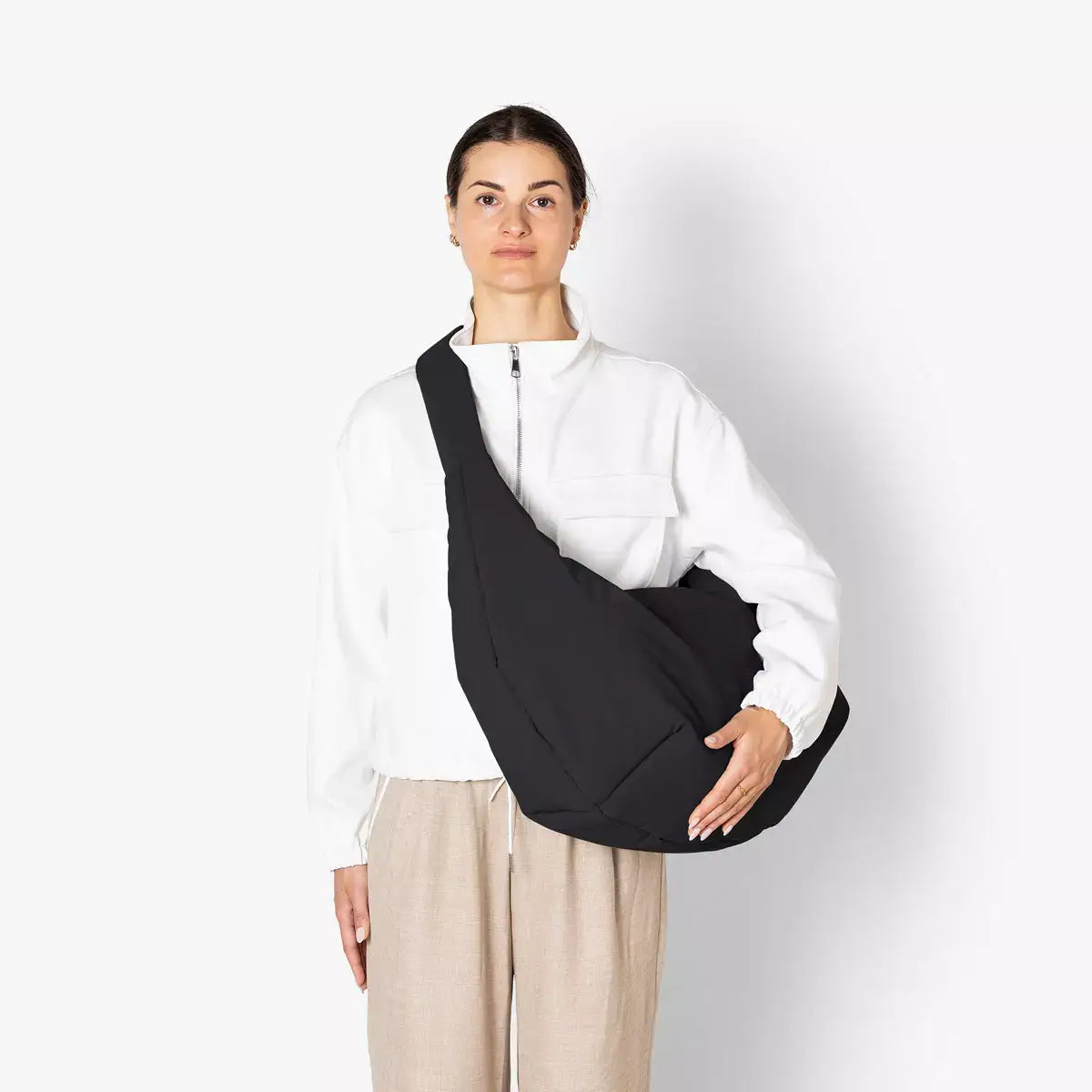 Shota Large Moss Black Shoulder Bag worn by a model, showcasing its water-resistant design and padded adjustable strap.