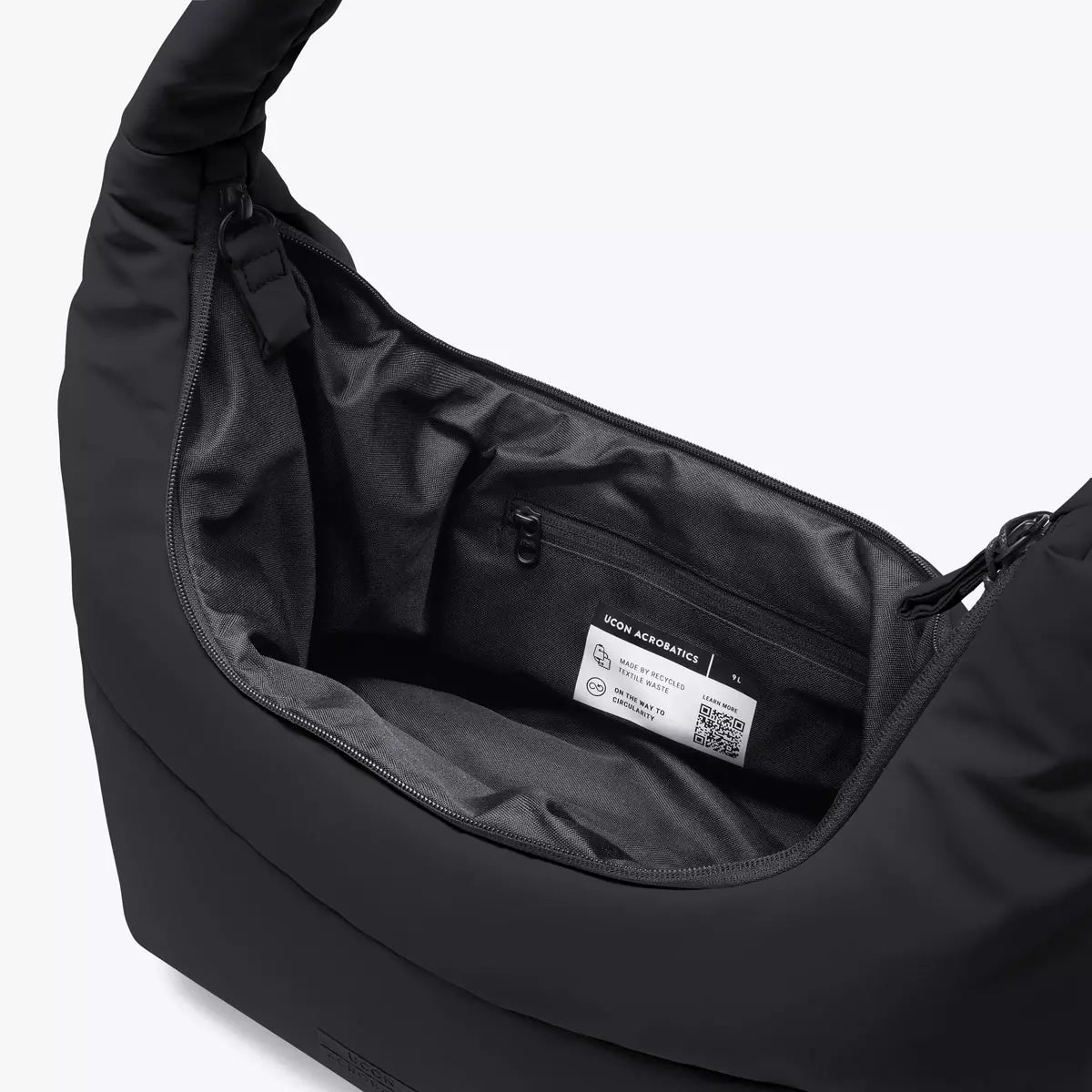 Interior view of Shota Medium Moss Black Shoulder Bag featuring zipper pocket and spacious design.