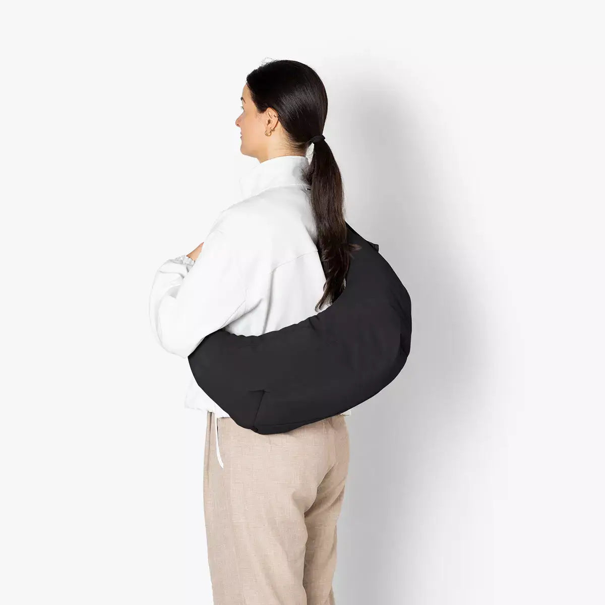 Shota Medium Moss Black Shoulder Bag worn over the shoulder, showcasing its sleek design and comfort.