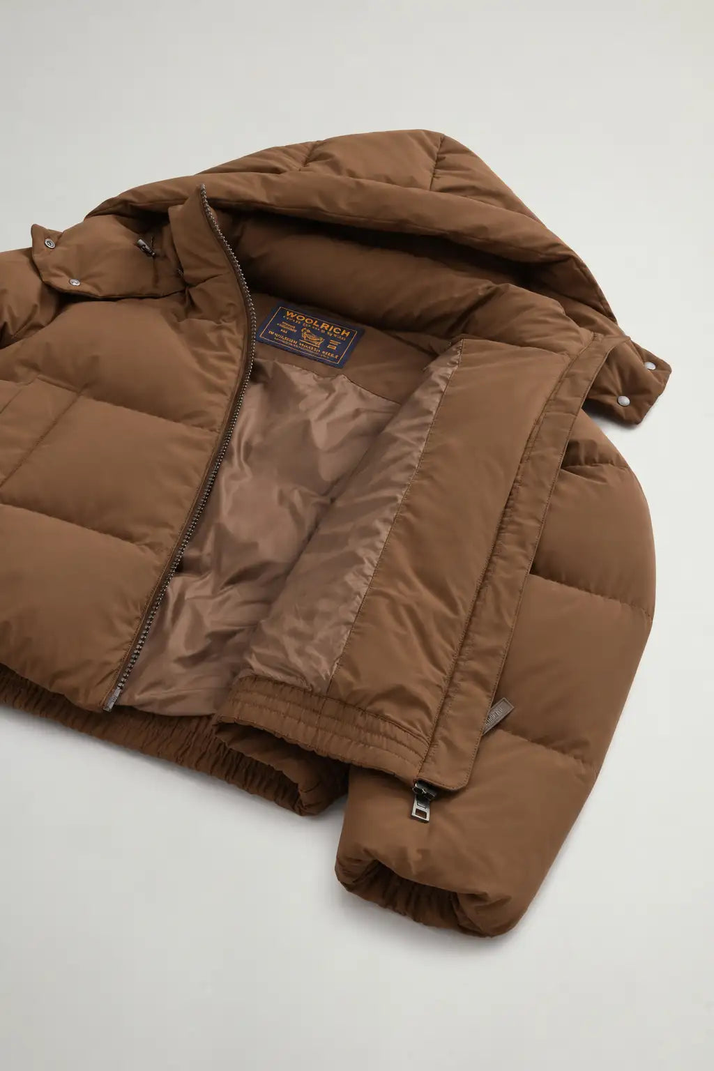Madison Jacket Dark Earth Coat interior view showcasing Woolrich branding and premium down filling.