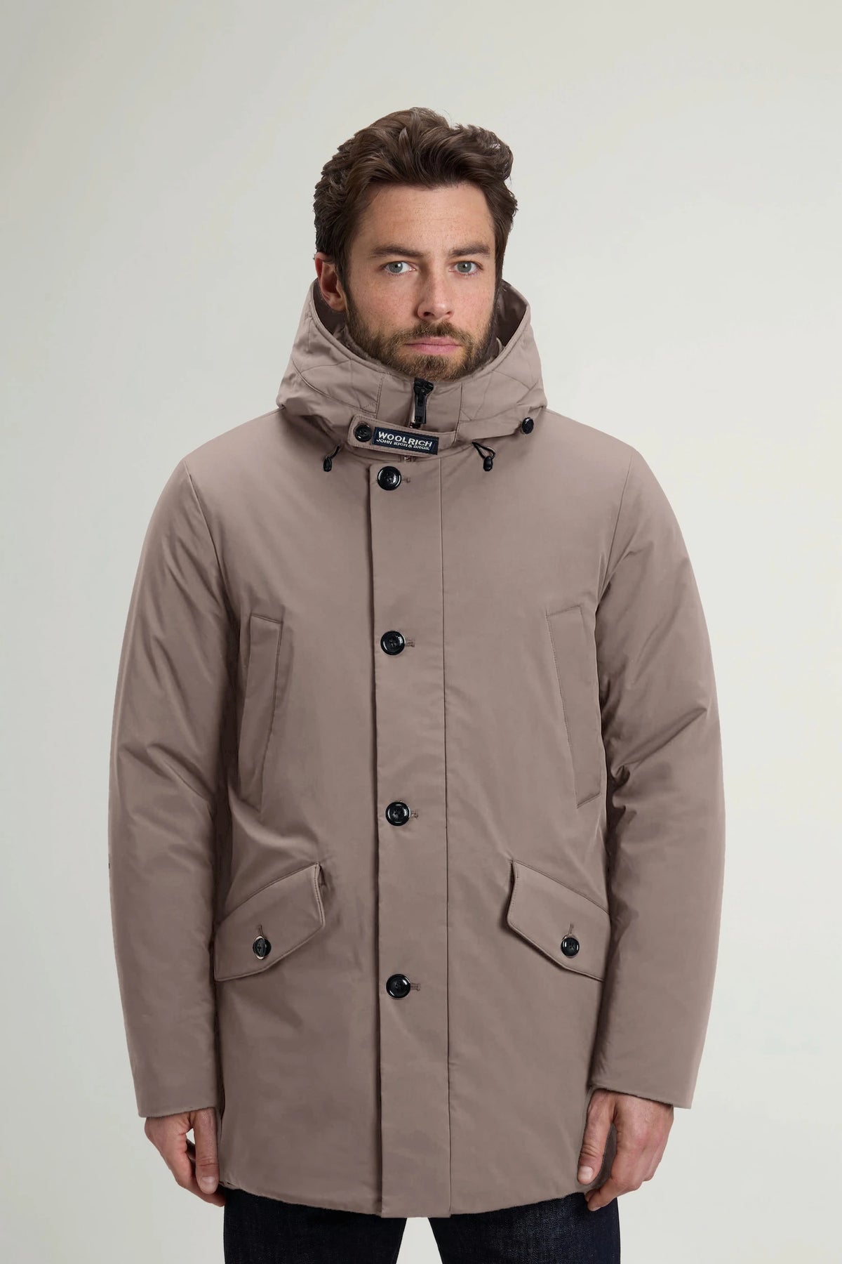 Man wearing a Stretch Parka Falcon Coat by Woolrich, showcasing its windproof and water-repellent features.