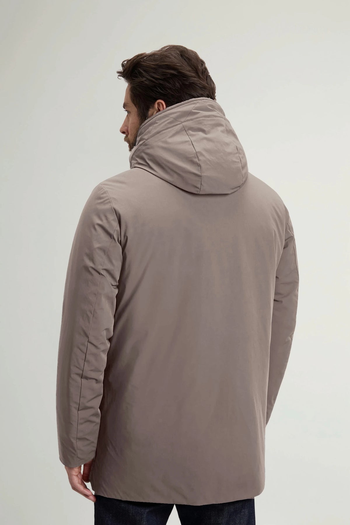 Rear view of a man wearing the Stretch Parka Falcon Coat by Woolrich, showcasing the stylish hood and sleek design.