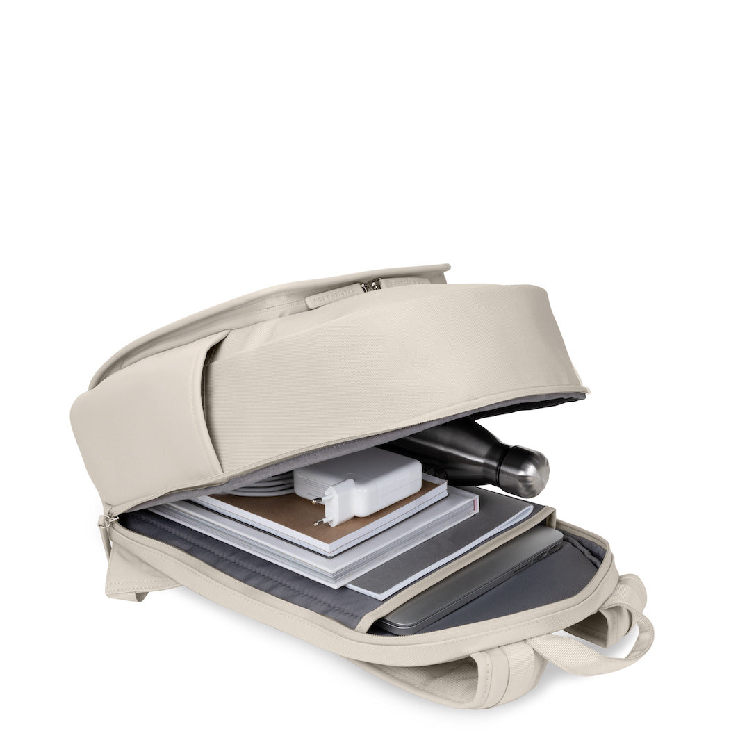 Aalborg Sandstone Backpack open with books, laptop, and accessories inside for functional storage.