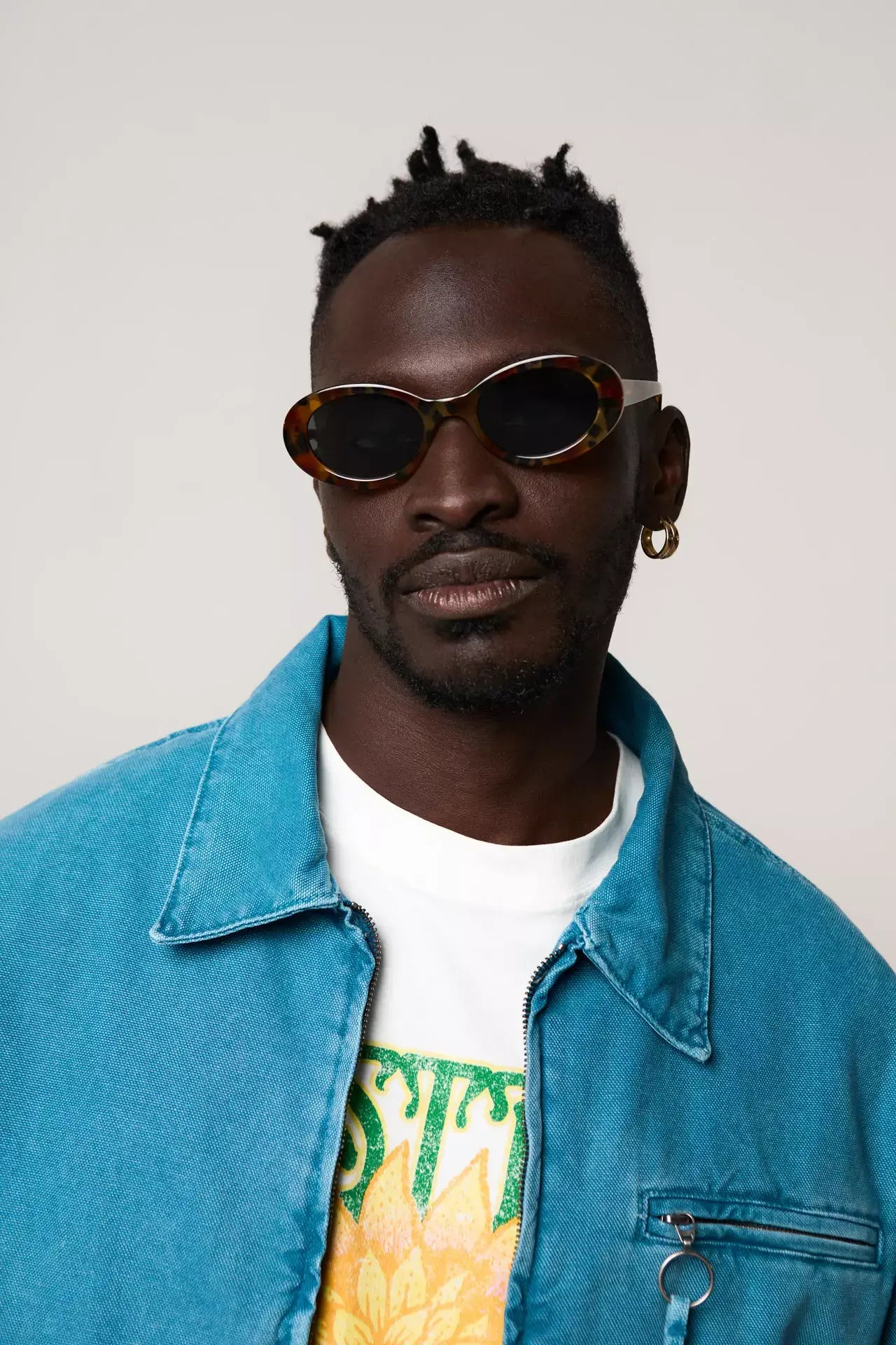 Ana Amber Shell Sunglasses worn by a model in a blue jacket, showcasing UV 400 protection and eco-friendly materials.