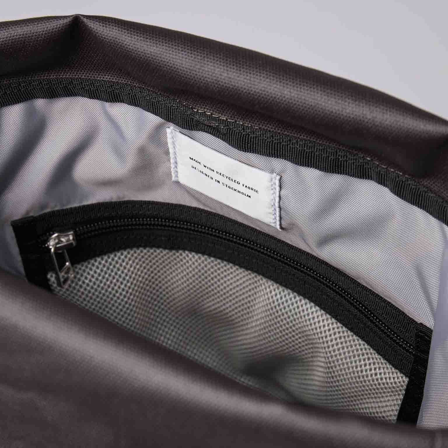 Inside view of the Arvid Multi Green Backpack shows inner pocket with zipper and lining.