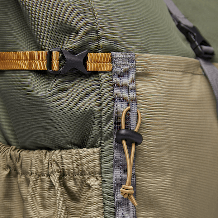 Close-up of the strap and roll-top closure of the Forest Hike Trekk Green Backpack.