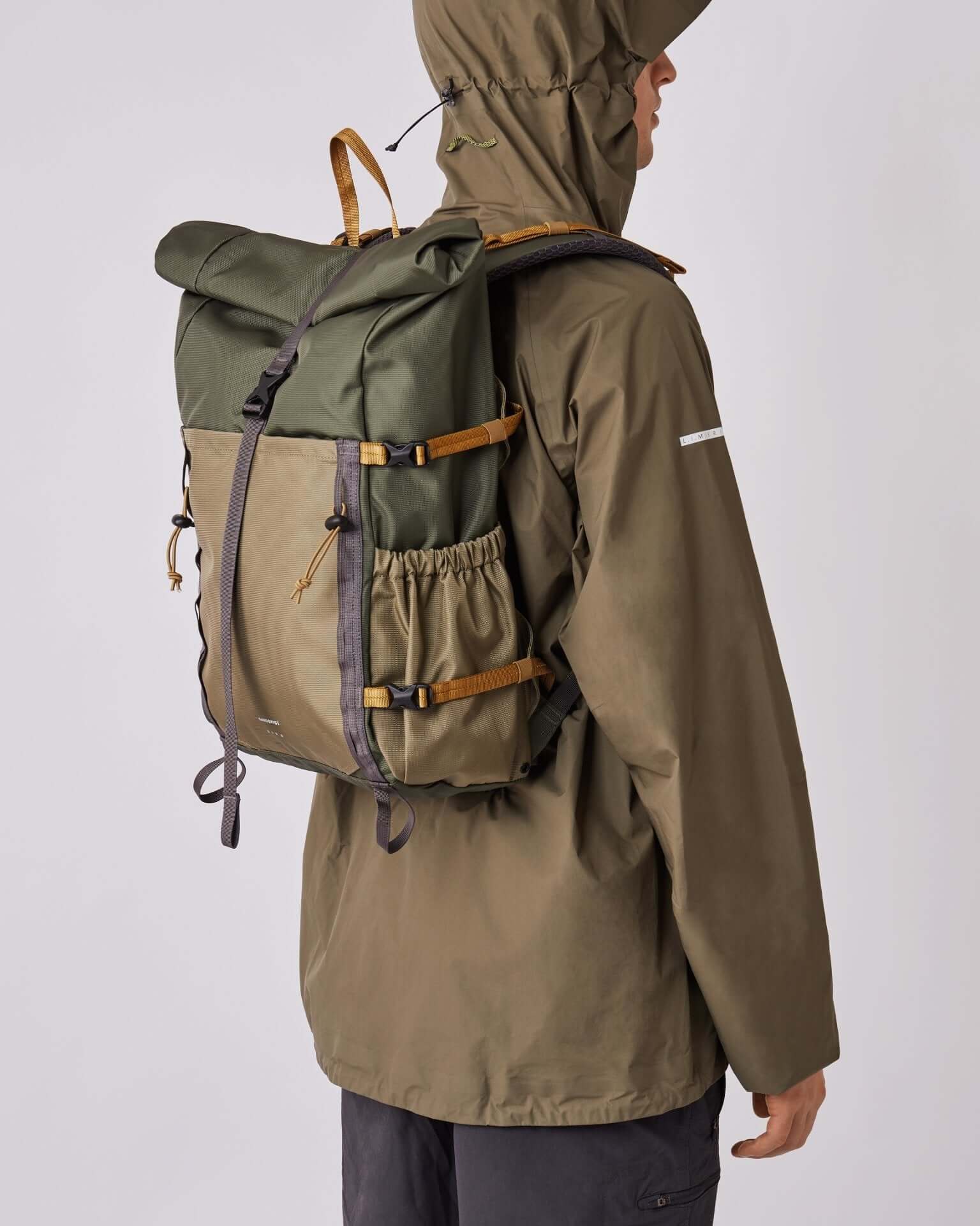 Person wearing Forest Hike Trekk Green Backpack with roll-top closure, ergonomic design, and water-resistant material.