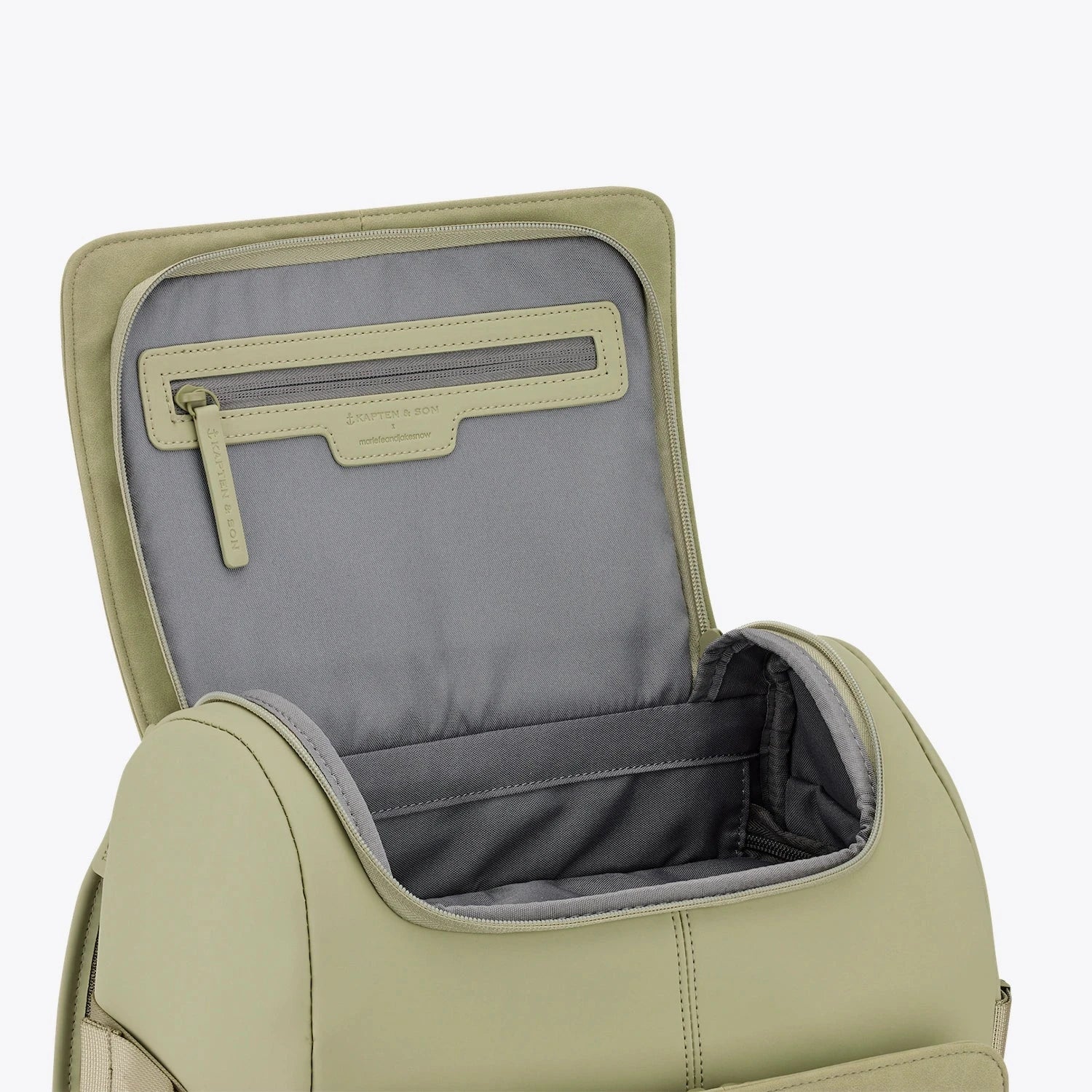Interior view of the Bali Dusty Pistachio Backpack showing zippered pocket and spacious compartment.