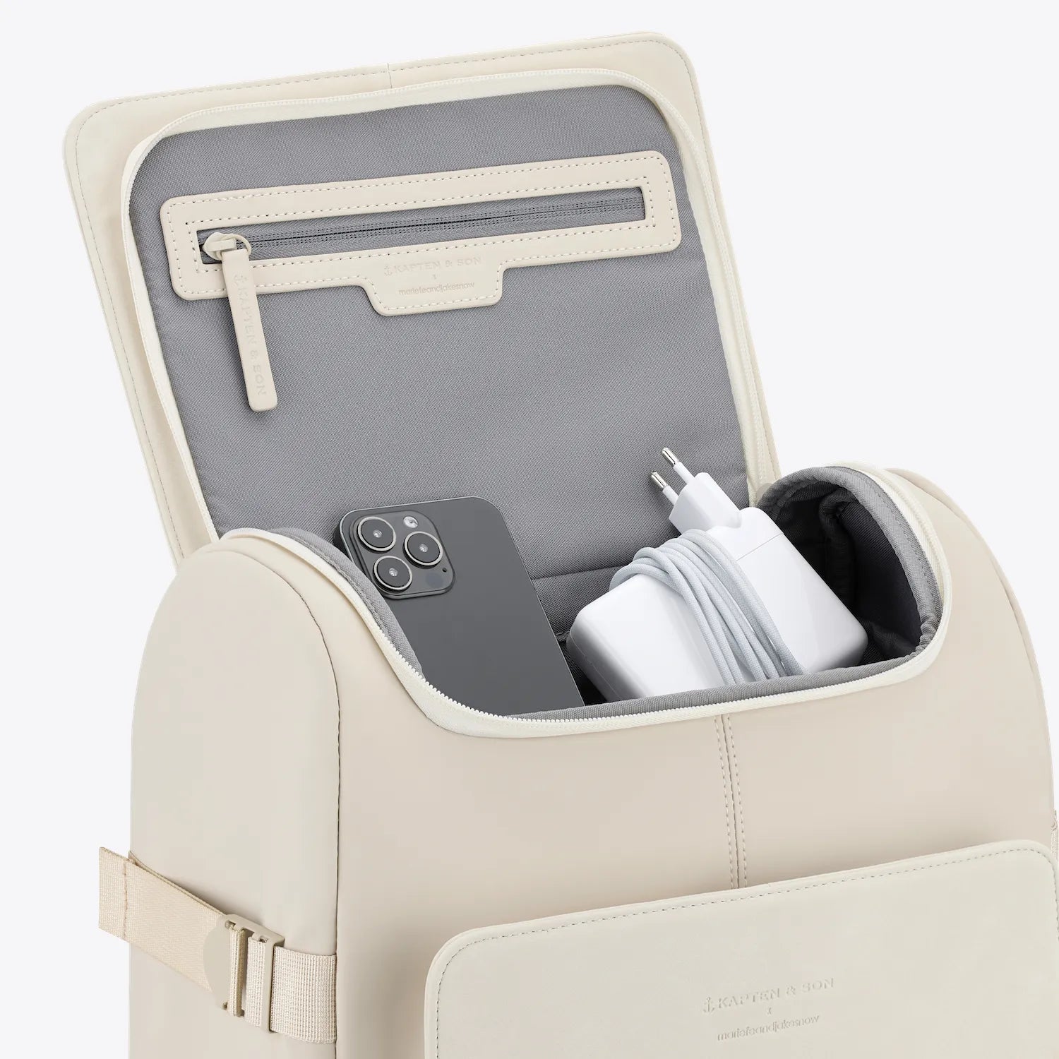 Bali Sandstone Backpack showing its interior with a smartphone and charging accessories