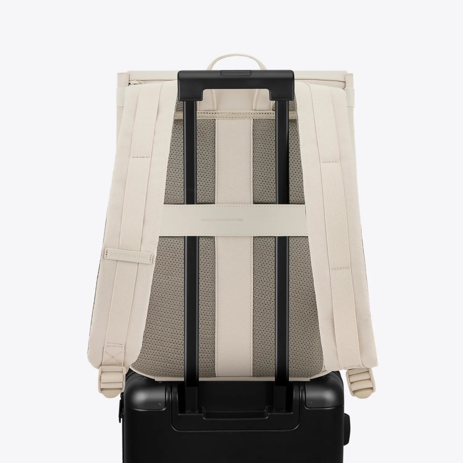 Fyn Sandstone Backpack on suitcase showing minimalist design and adjustable straps for easy travel.
