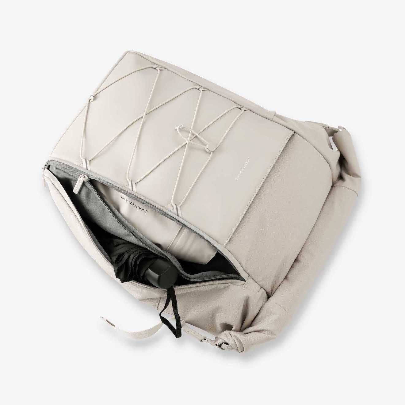 Yoho Sandstone Backpack interior view showing magnetic buckles, zipper closure, and padded straps.