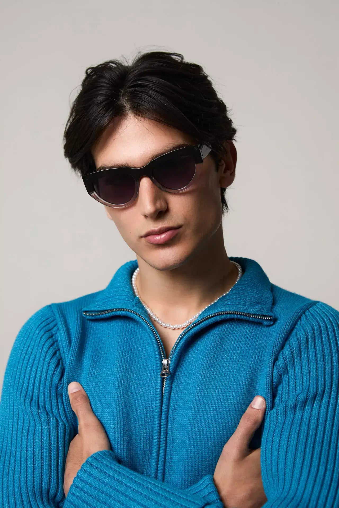 Model wearing Kim Emerald Shadow Sunglasses with a blue sweater, showcasing stylish UV protection and eco-friendly design.