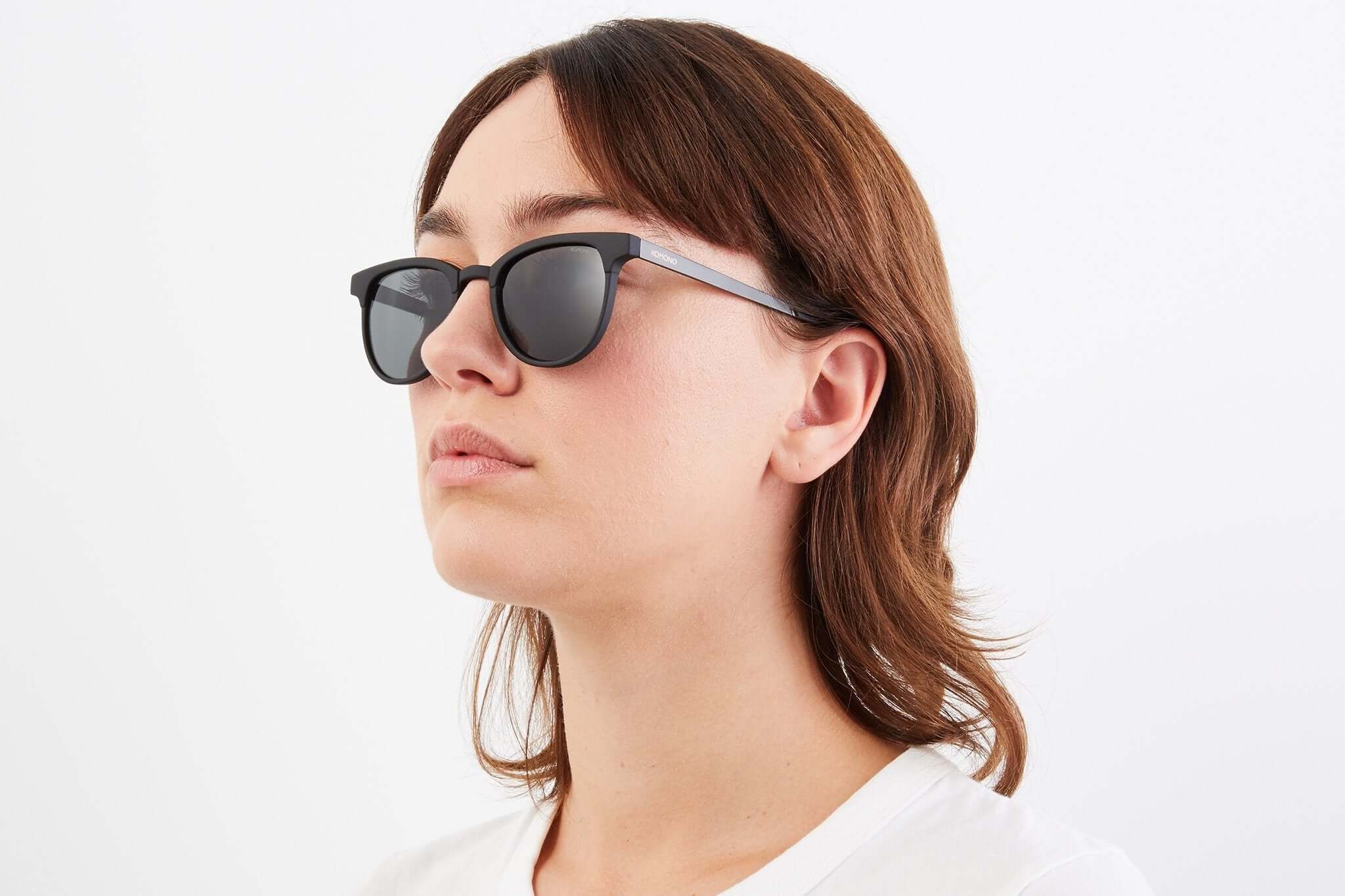 Francis Metal Black Sunglasses worn by a woman, featuring UV 400 protection and scratch resistant lenses.