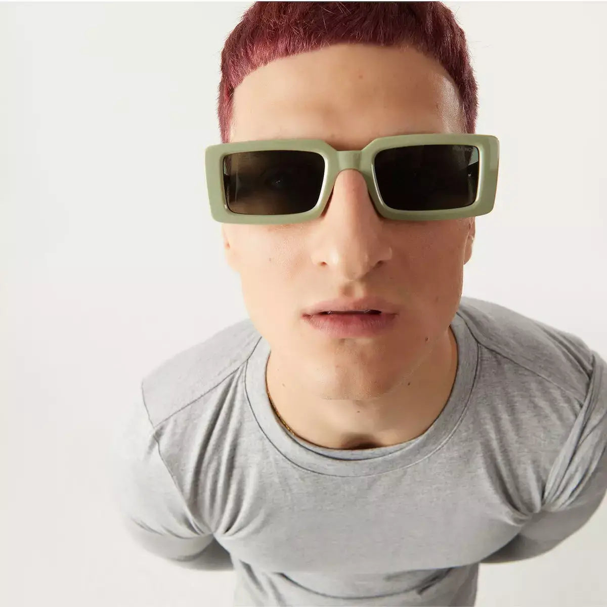 Malick Moss Sunglasses on a model with a short haircut, showcasing the solid green eco-made frame.