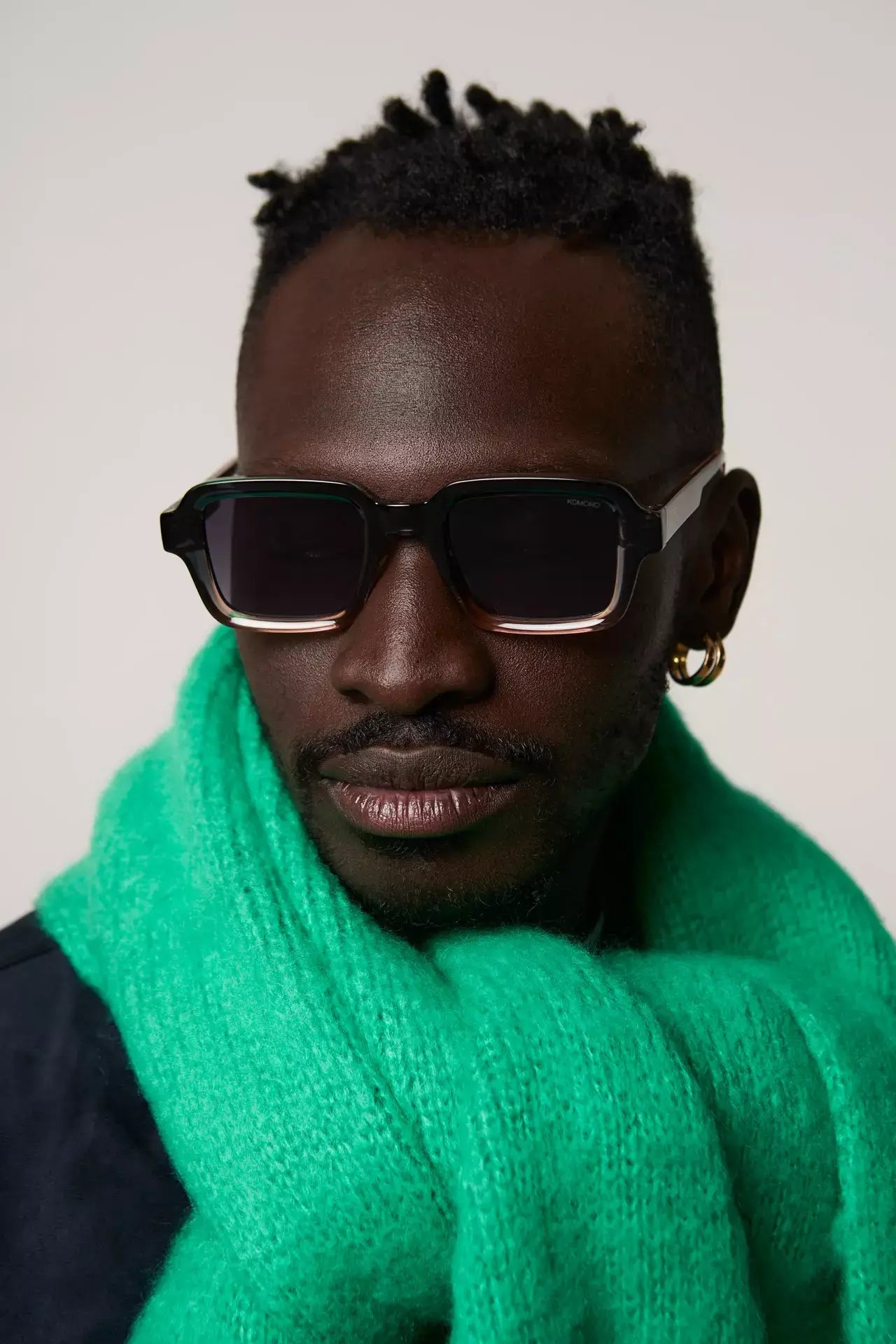 Model wearing Lionel Atlantic Sunset Sunglasses with a green scarf, showcasing UV protection and stylish design.