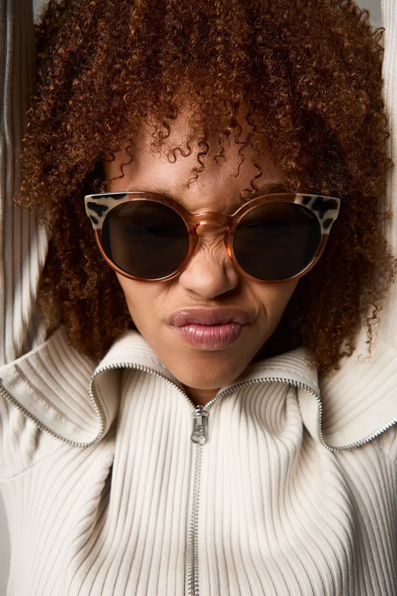 Model showcasing Lulu Coral Bobcoat Sunglasses with cat eye design, UV protection, and eco-friendly frame.