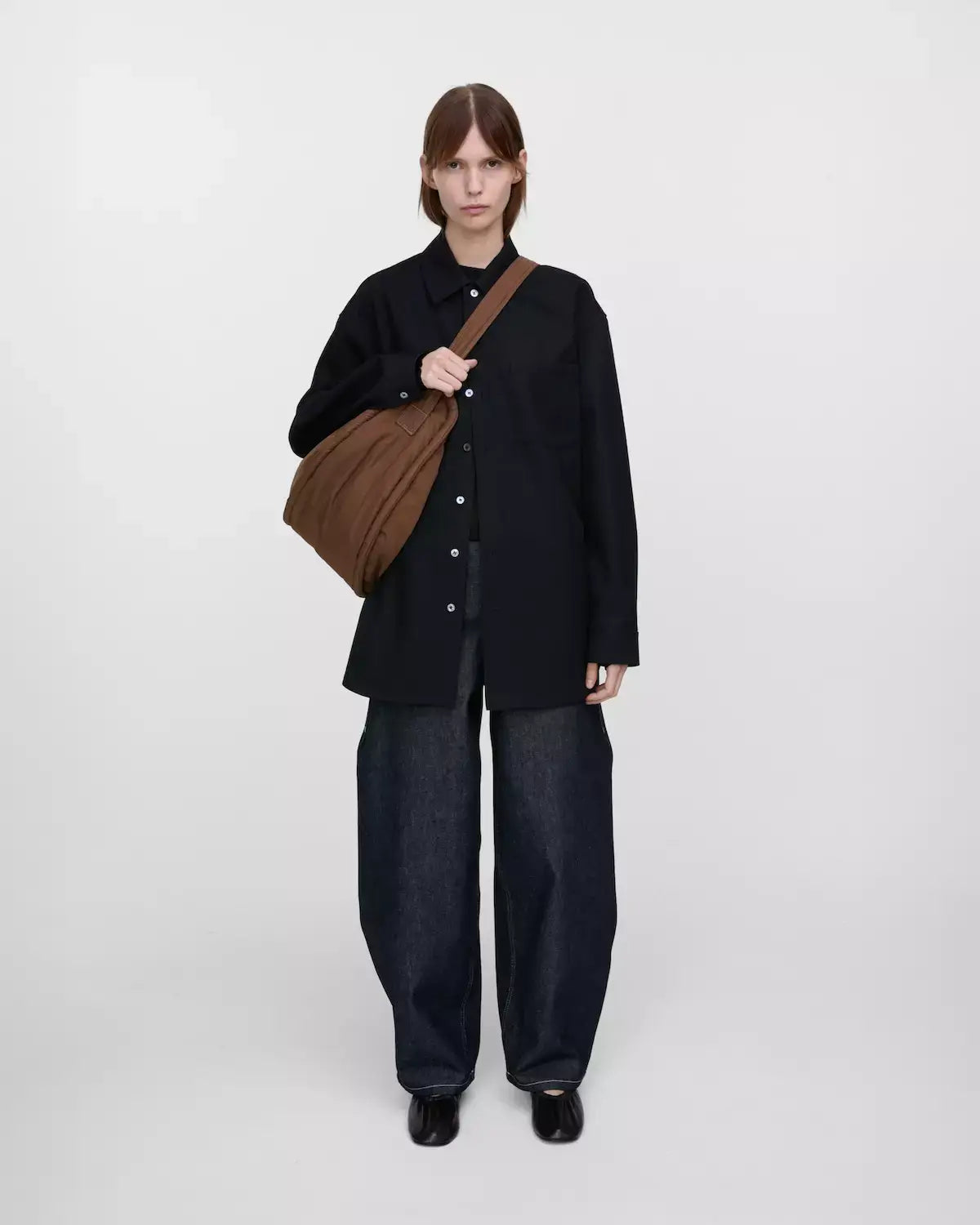 Model showcasing the Curve Crossbody Round L Dark Taupe Shoulder Bag with a stylish outfit.