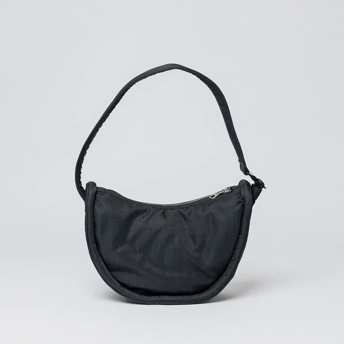 Curve Crossbody Round S Black Shoulder Bag in black recycled nylon, featuring a padded shoulder strap and zipper pocket.