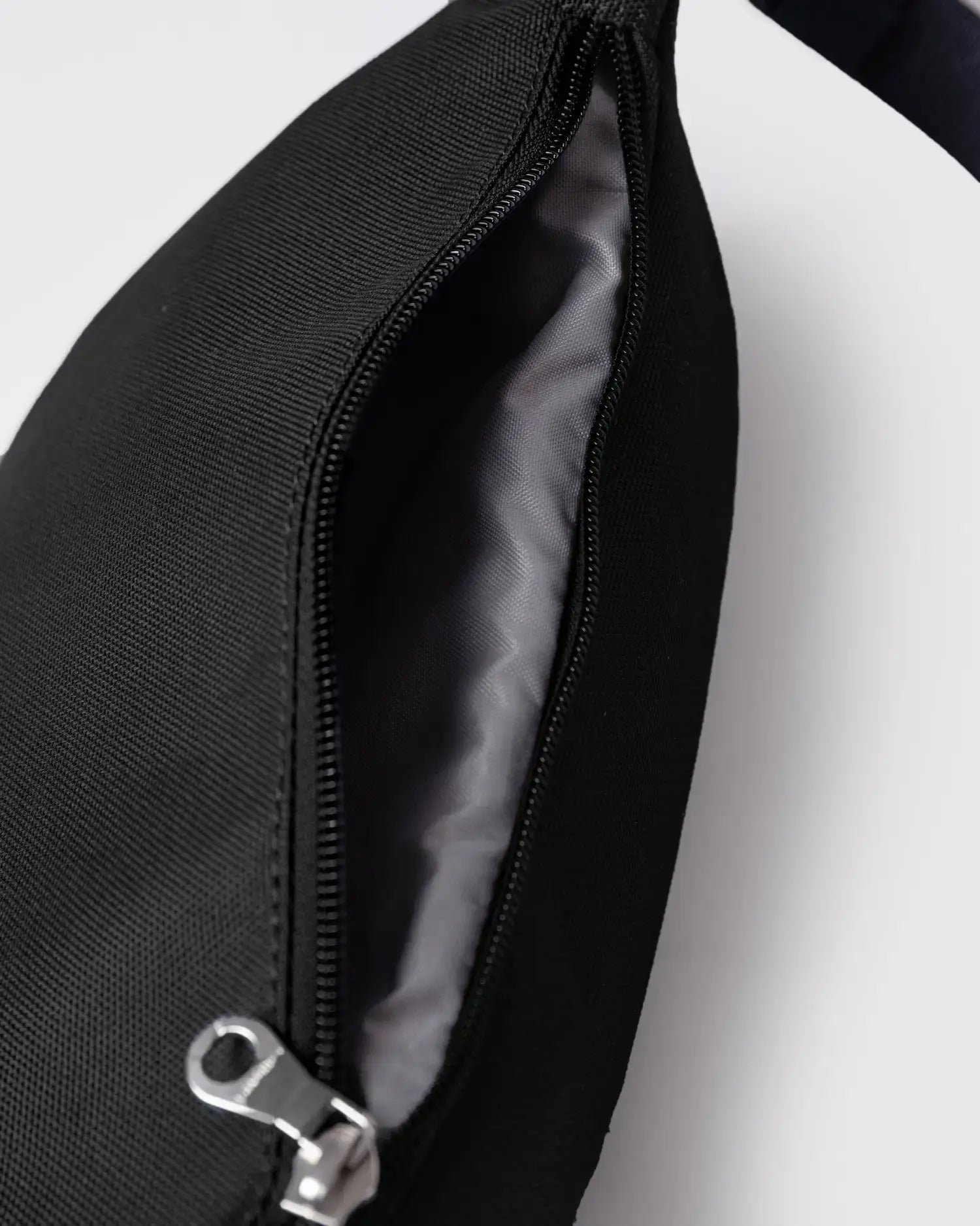 Ground Crossbody Bag Black Bum Bag showing zipper opening and interior design.