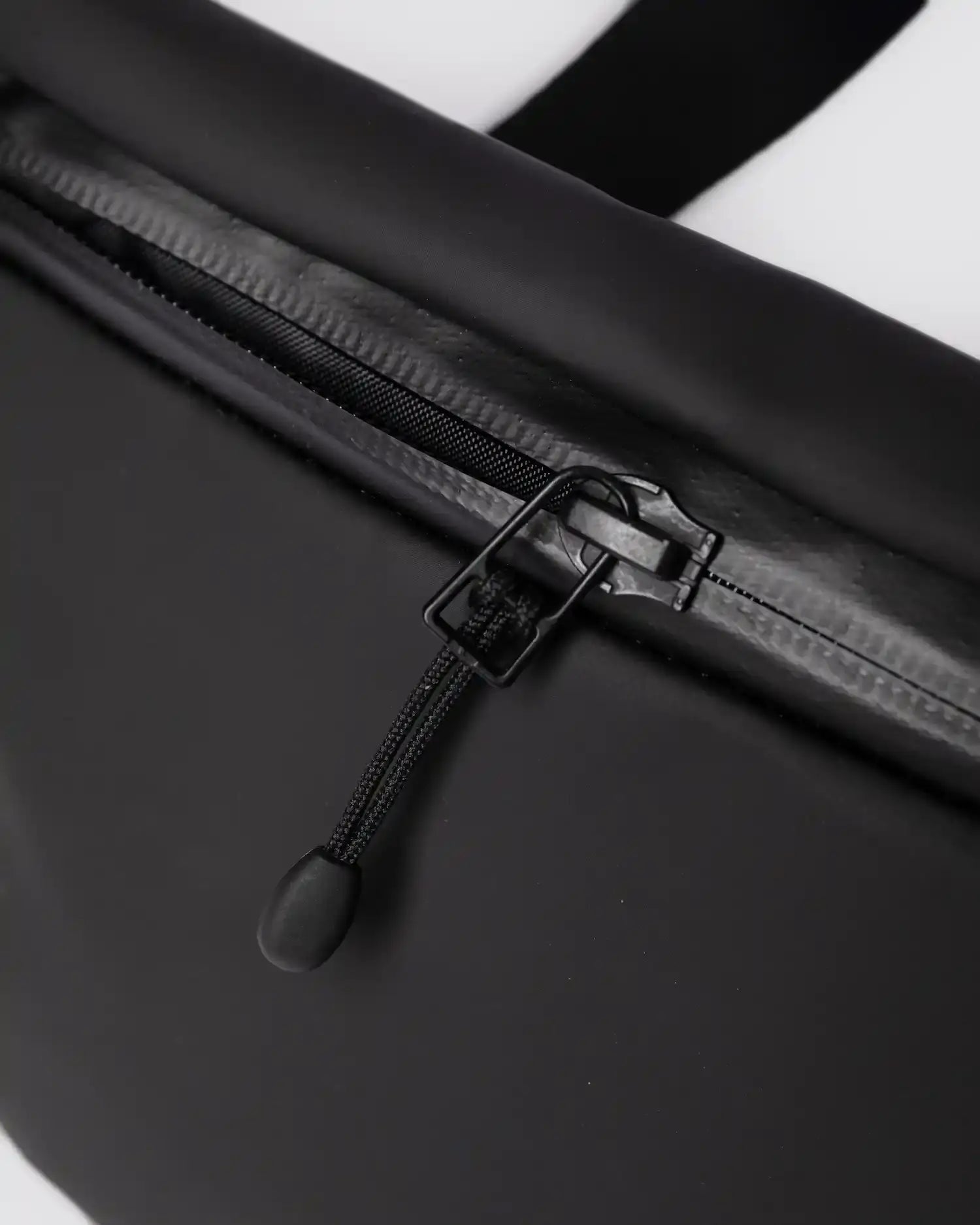Close-up of the zipper on the Stream Messenger Mini Black Shoulder Bag, showcasing its waterproof design.