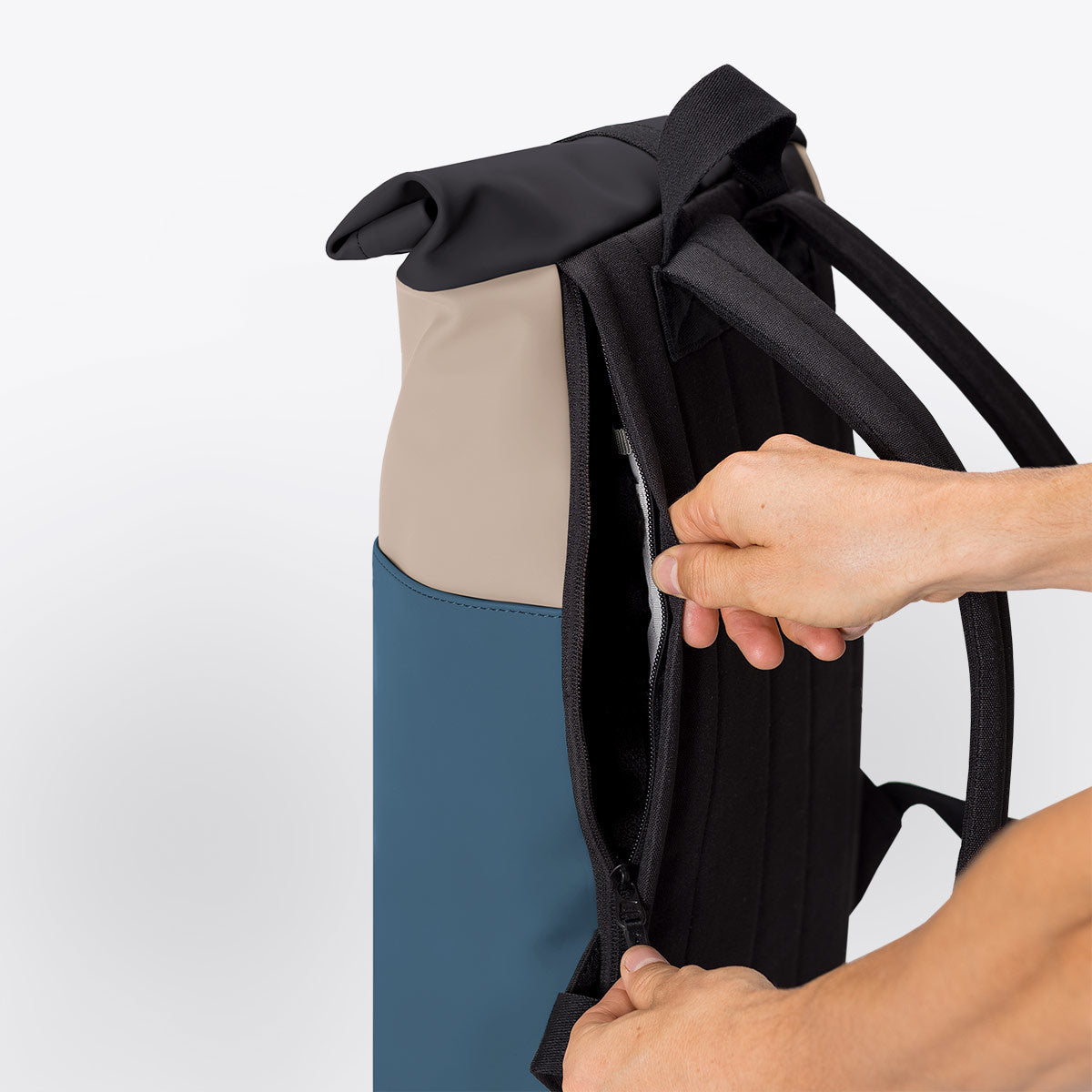 Hajo Mini Lotus Nude Petrol Backpack showing the roll-top closure and zipper access for easy packing.